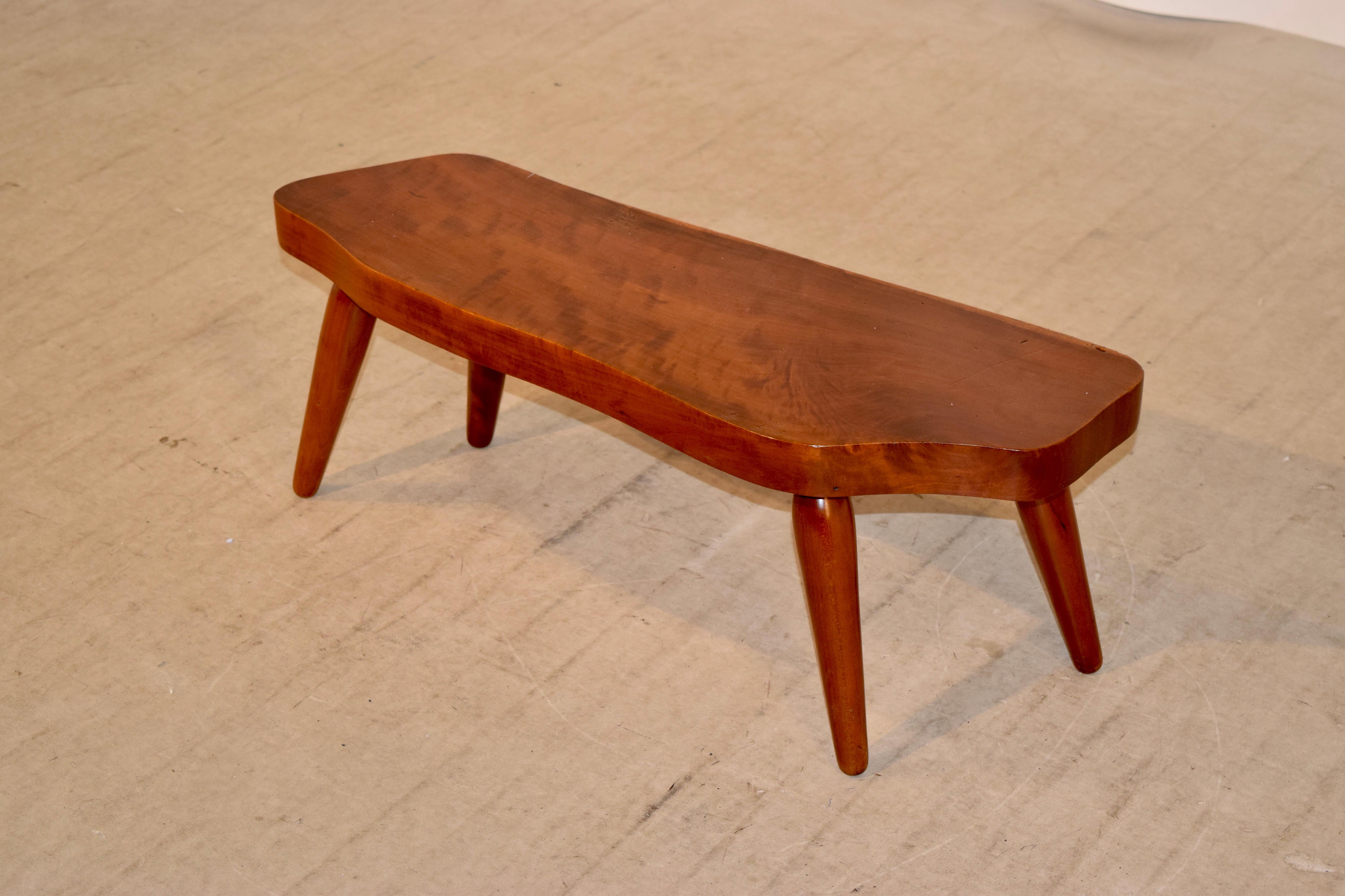 Handmade cocktail table made from Cherry in the North Carolina mountains, circa 1960. The table was purchased from the famed Moses Cone Craft Center in 1960, which housed all of the finest Appalachian craftsman at that time. The table is a slice of