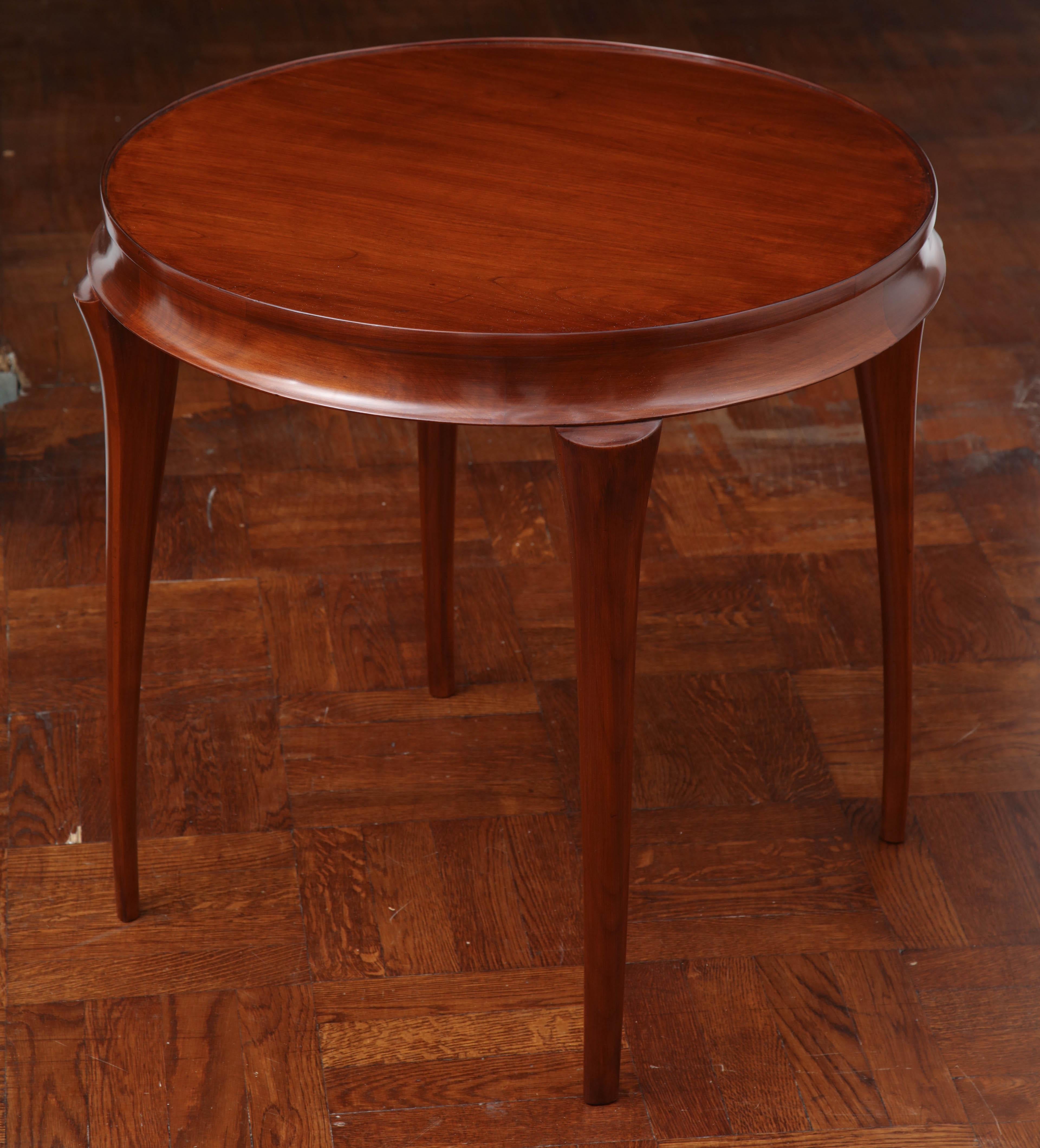 Round cherry table with tapered legs.