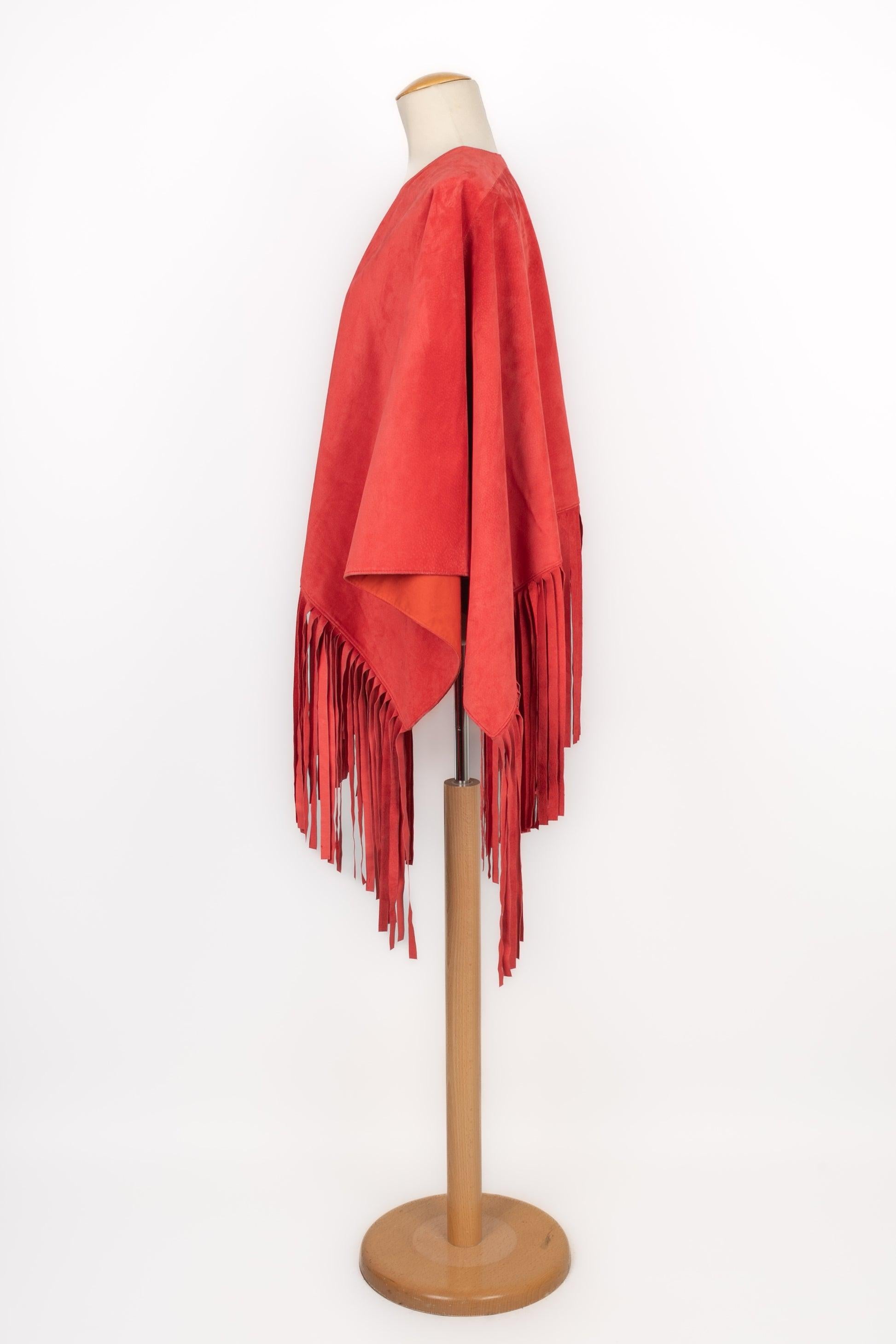 Cherry-red inside-out leather cape with fringes. Cotton lining.

Additional information:
Condition: Very good condition
Dimensions: Length without the fringes: 65 cm - Width: 130 cm

Seller Reference: M126