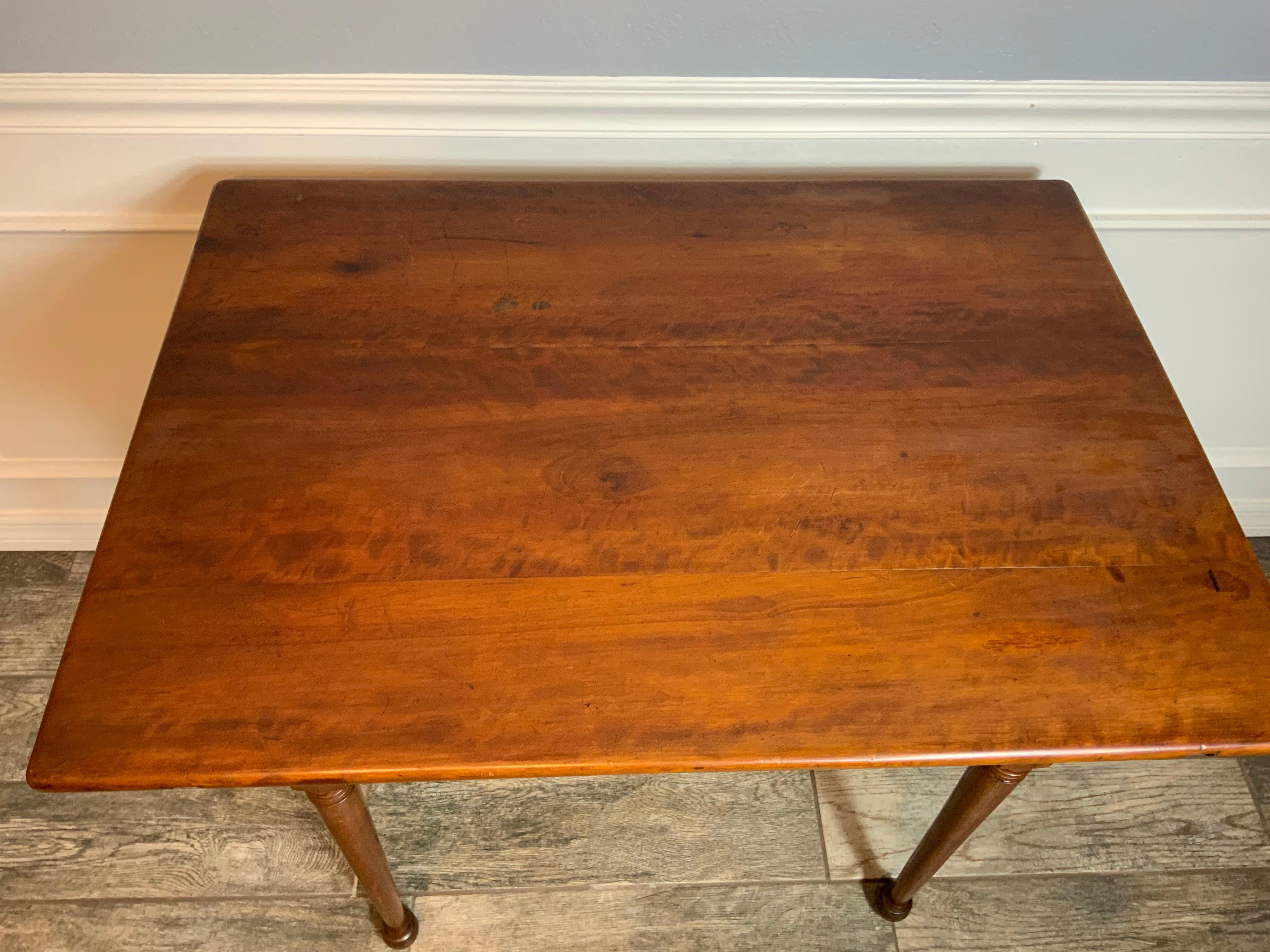 Très belle table de taverne ou d'appoint en cerisier et en pin de la Nouvelle-Angleterre, datant du XIXe siècle, avec un plateau amovible à queue d'aronde. Le dessus est maintenu en place par quatre chevilles à travers le tablier. Très belle couleur