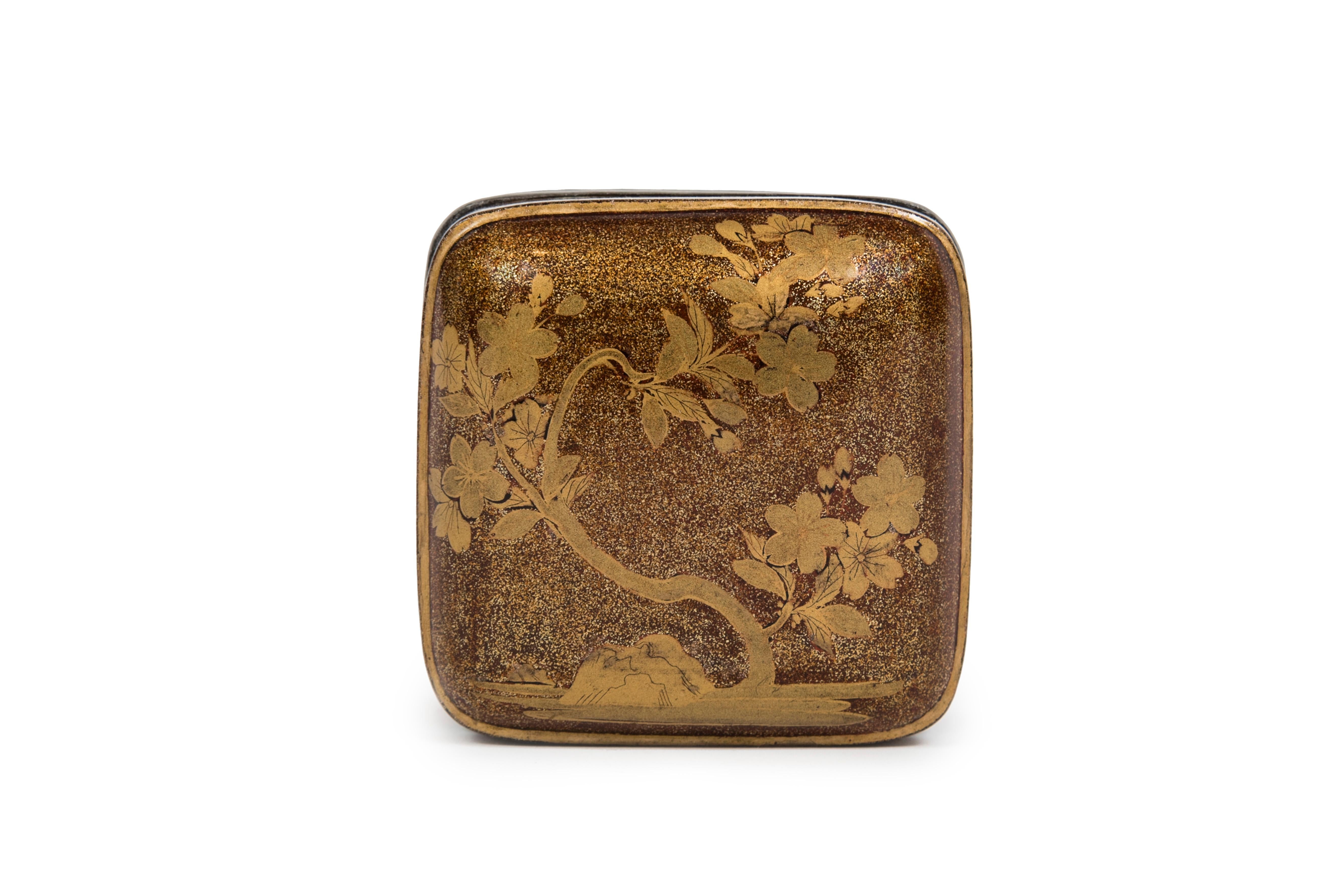 Kobako in nashiji lacquer of square shape with a hira maki-e décor of a blossoming 
cherry tree. Both of the four sides are adorned with golden lacquer cherry flowers, 
represented in both profile and seen from above. The inside is made of hirame
