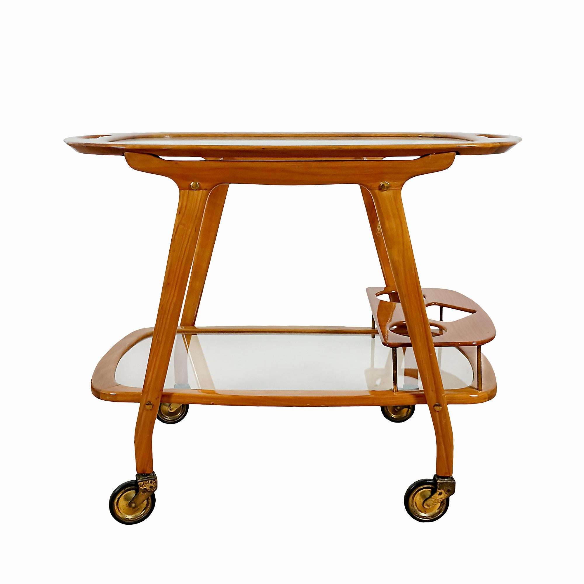 Solid cherry wood and glass bar cart with removable tray, bottle rack on the lower level and brass wheels and finishes. Original polyurethane varnish in good condition.
Design: Cesare Lacca

Italy c. 1950