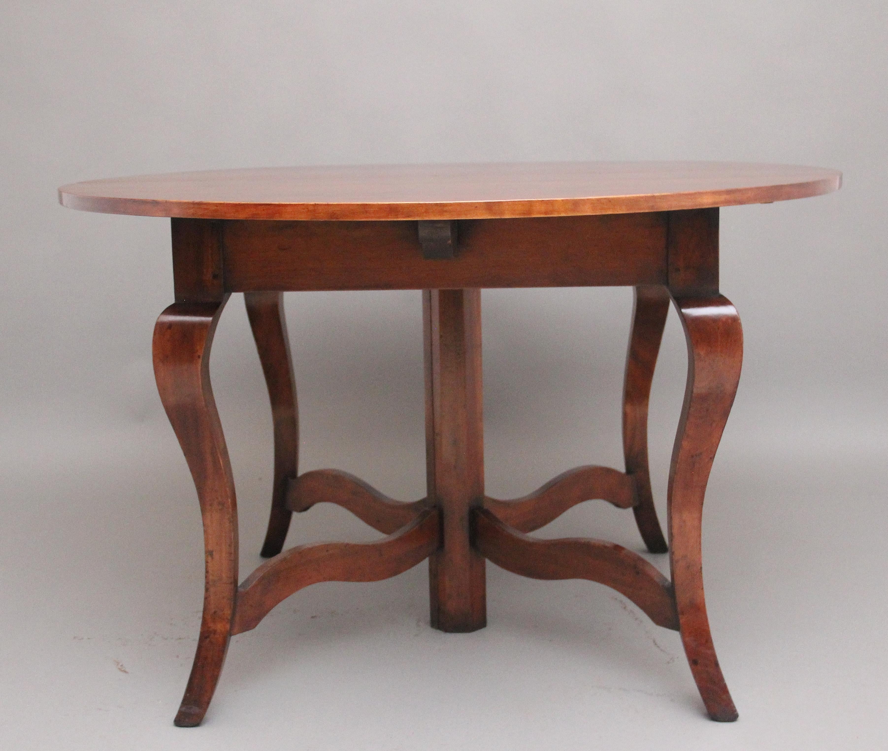 A solid cherry wood extending table with two leaves / extensions in the country French style, the table has a circular shape when closed and once fully extended becomes an oval shaped table,  the table can be used with the two leaves or the one when