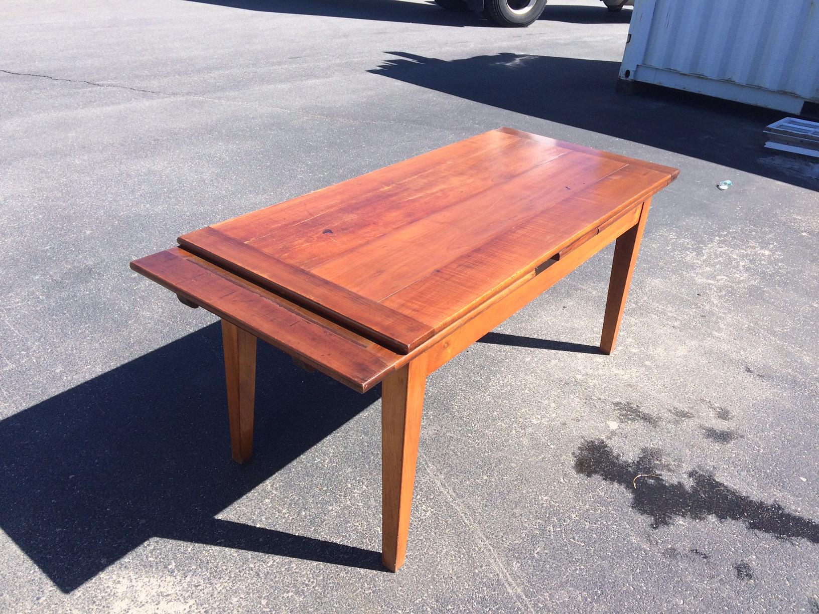 Beautiful vintage fiery red cherry wood European Draw Leaf Table with a four board top and breadboard ends, straight skirt and tapered legs. This pieces gives off a nice shine and is in excellent condition, structurally sound, and ready for a new