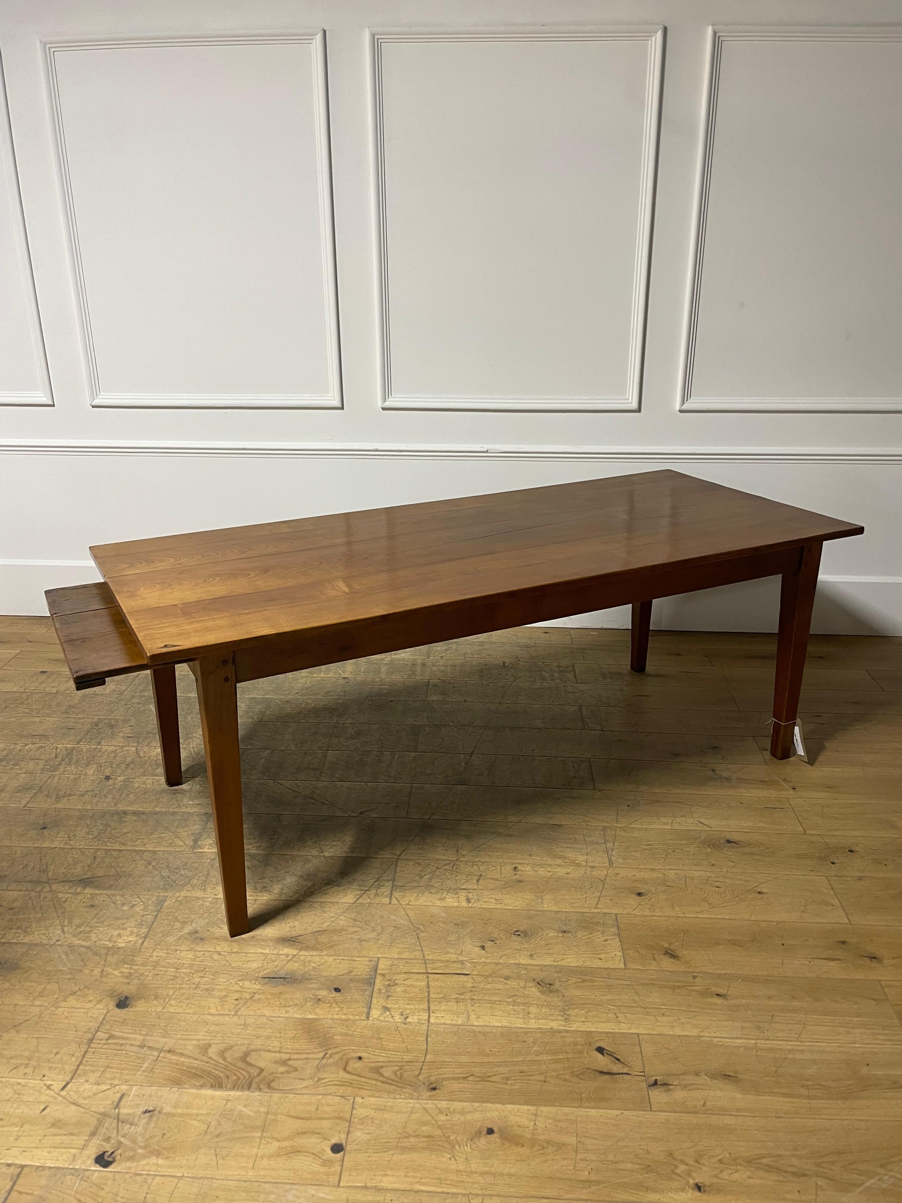 Très bel exemple de table de ferme française en merisier du milieu du 19e siècle. 

Datant des années 1860 et provenant de la région normande de la France, avec une belle couleur et patine. Avec une glissière à pain à l'une des extrémités. Peut