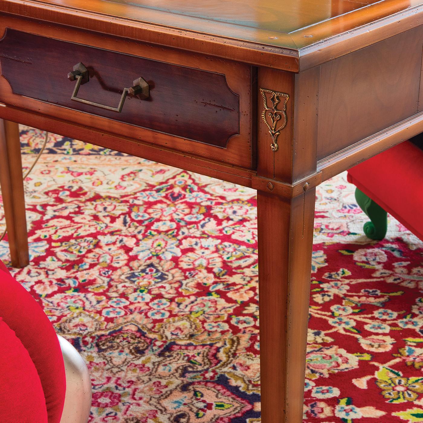 Defined by a classic silhouette, this exclusive writing desk is a unique piece of timeless elegance. The slender frame in European cherry wood features a cherry-veneered top marked by a darker outline and two front drawers with mocha-lacquered