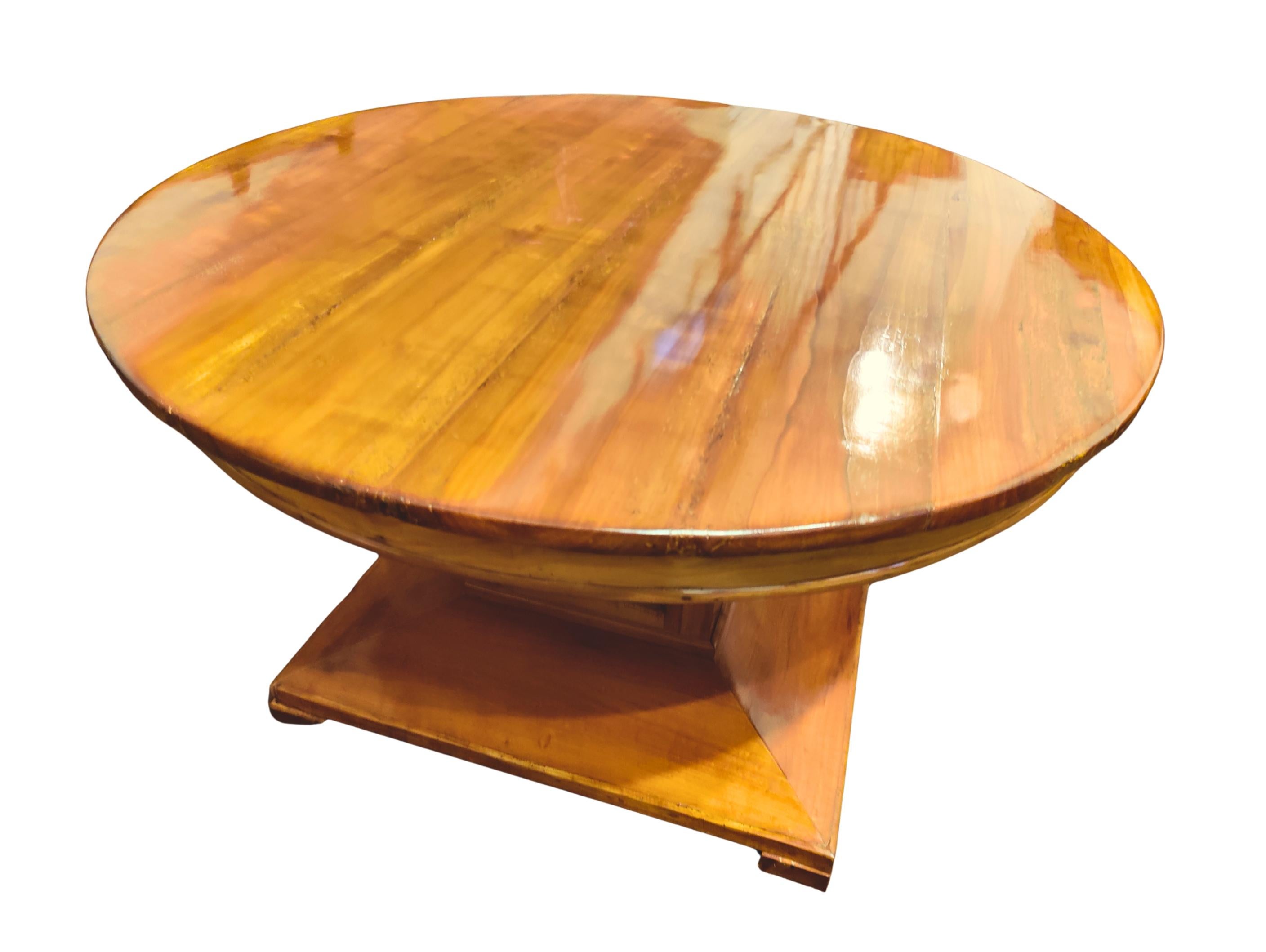 Elegant round center table from around 1910, designed in the late Biedermeier tradition with subtle influences of the Art Nouveau period. The piece is crafted from solid cherrywood and cherry veneer, displaying a warm golden tone and fine natural