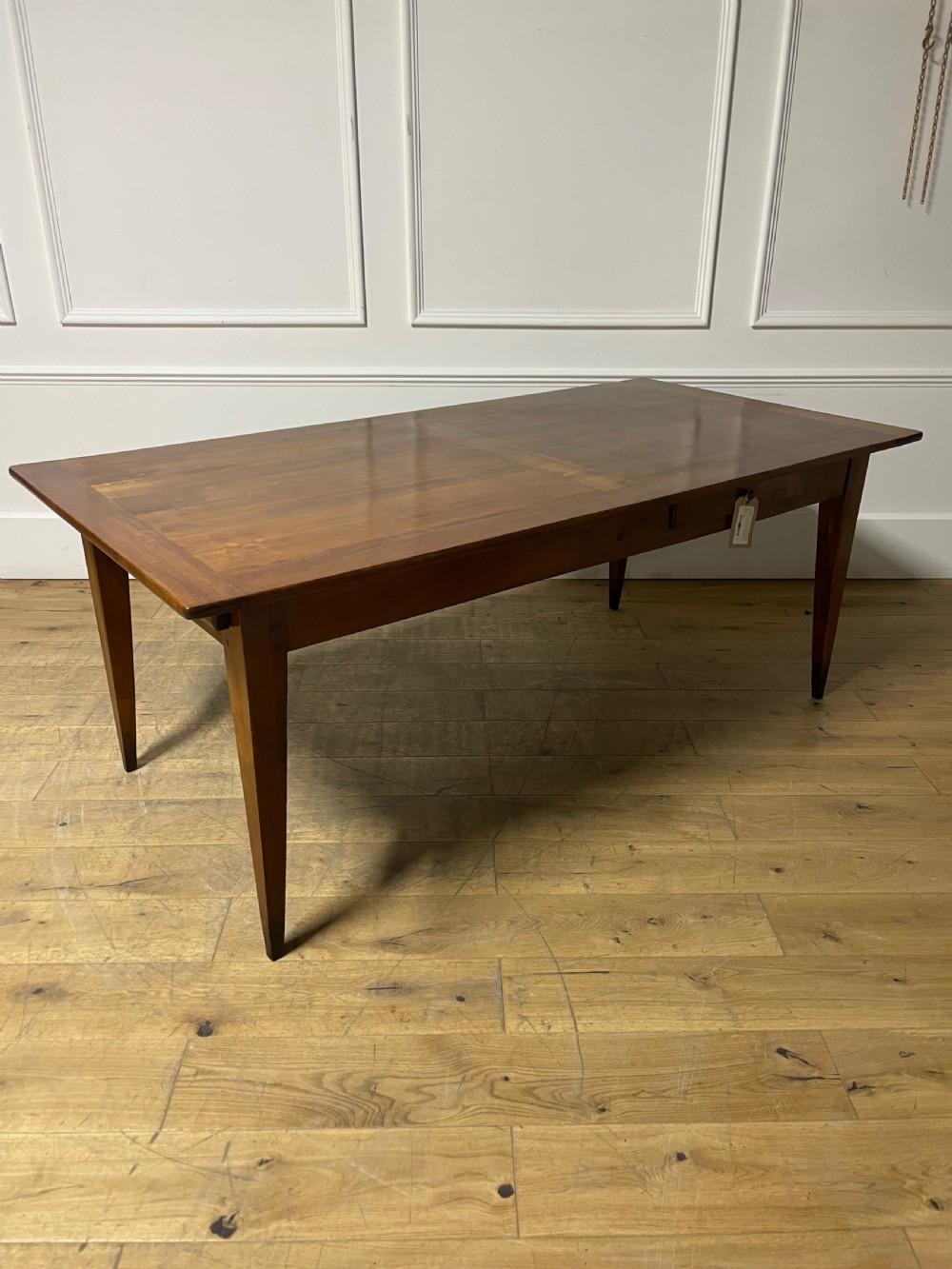 Très bel exemple de table de ferme en merisier du début du 20ème siècle, française vers 1920, reposant sur des pieds fuselés, avec une grande glissière pour le pain et un petit tiroir sur le côté.
Peut accueillir 6 à 8 personnes, beau plateau