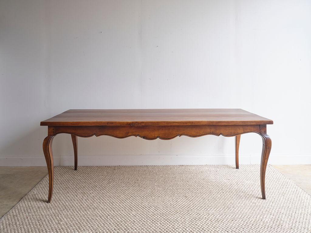 It does not get more classic and beautiful than this Cherrywood French dining table. The rich dark color of this table gives it a moody feel, as well as the curved feature of the legs. Along the under sides of the table, there is a lovely wood