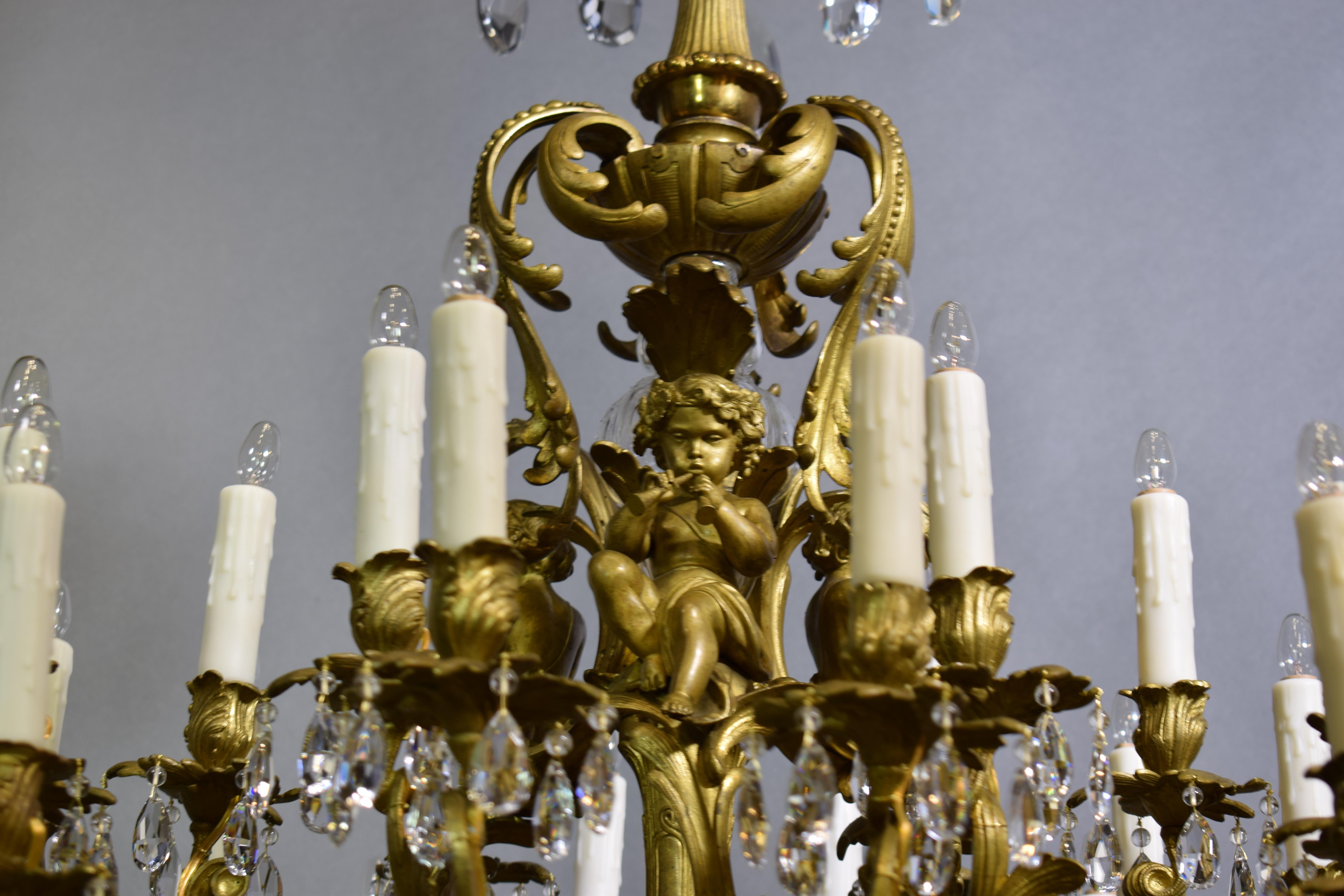 A very fine gilt bronze chandelier with crystal pendalogues, featuring cherubs playing different musical instruments, originally for candles now electrified. 24 lights. France, circa 1890.
Measures: 41