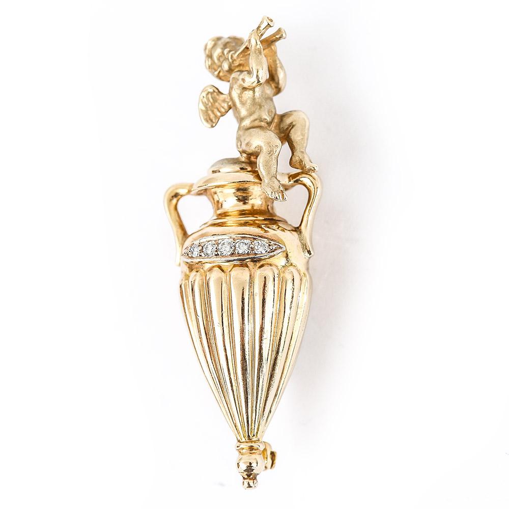 A charming solid 14 karat yellow gold finely modelled cherub/angel playing two horns sitting upon a diamond set classical urn. The vintage gold cherub is finished in a matte gold which contrasts with the bright finish of the urn. The five claw set