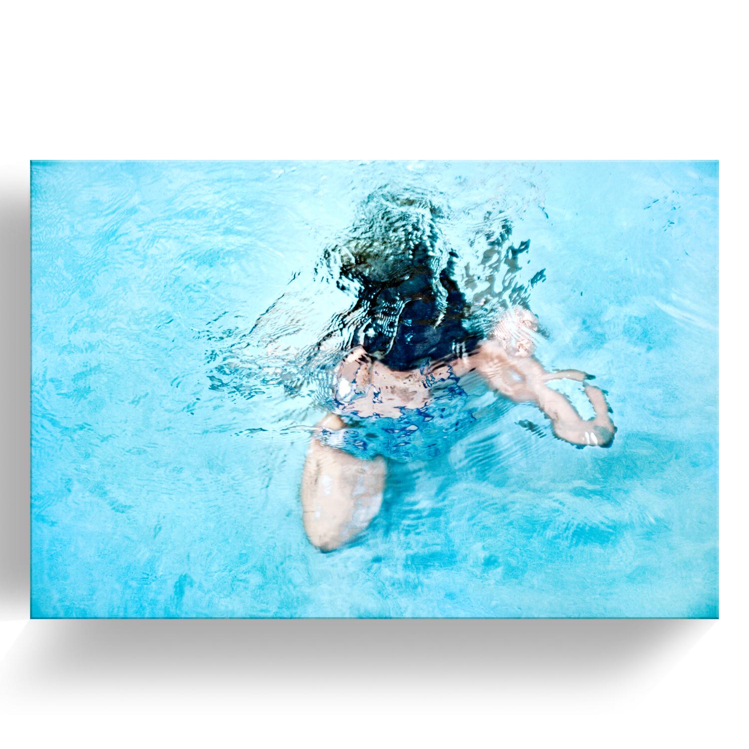 'Submerge V' Mounted Plexiglass Limited Edition Photograph features a female figure underwater in bright reflective tones of blue, beige, and black. Inspired by nature and human connectivity, the intimacy behind her work is evident. Renowned and