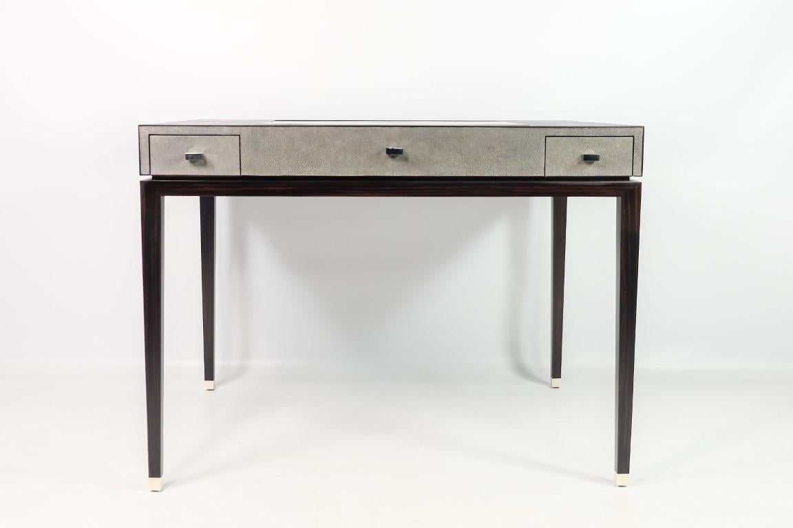 This 2 in  1 game table is for the chess and backgammon gamers.
It has a pivot game board and 4 drawers. 
It is made of shagreen with wood (macassar veneer) legs and bone caps. 

The chess game is made of 2 colours wood and the backgammon game is