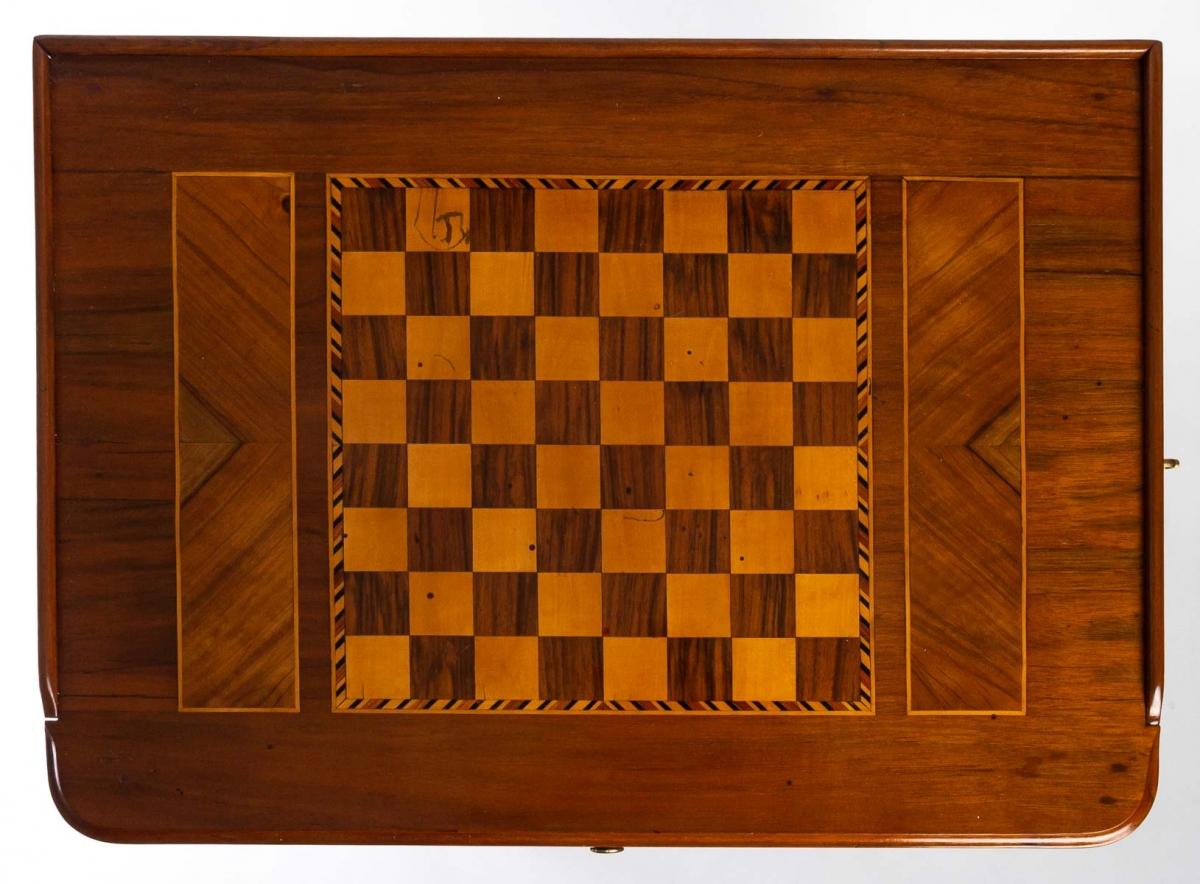 Chess table, 1780 - 1790
The two sides are made of yew and walnut veneer.
Four sheath feet with gold plated shoes elegantly underline a second top, revealing an equally sublime marquetry of precious woods.

Period: 18th century
Circa : 1780 -
