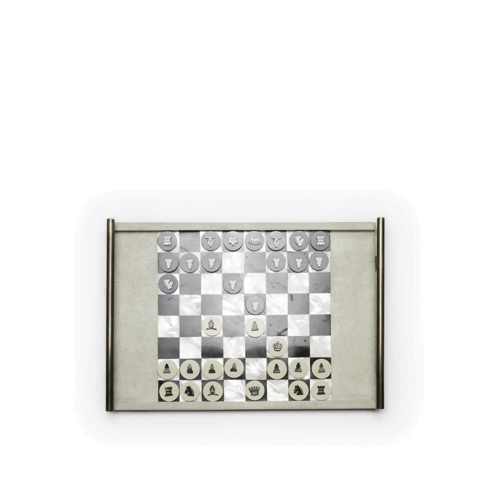 Le plateau du jeu d'échecs Kifu Paris est le jeu de luxe par excellence. Accentuée par un mélange de galuchat, de coquille de stylo et de laiton bronze-patiné, cette pièce est livrée avec toutes les pièces du jeu dans une pochette en velours.