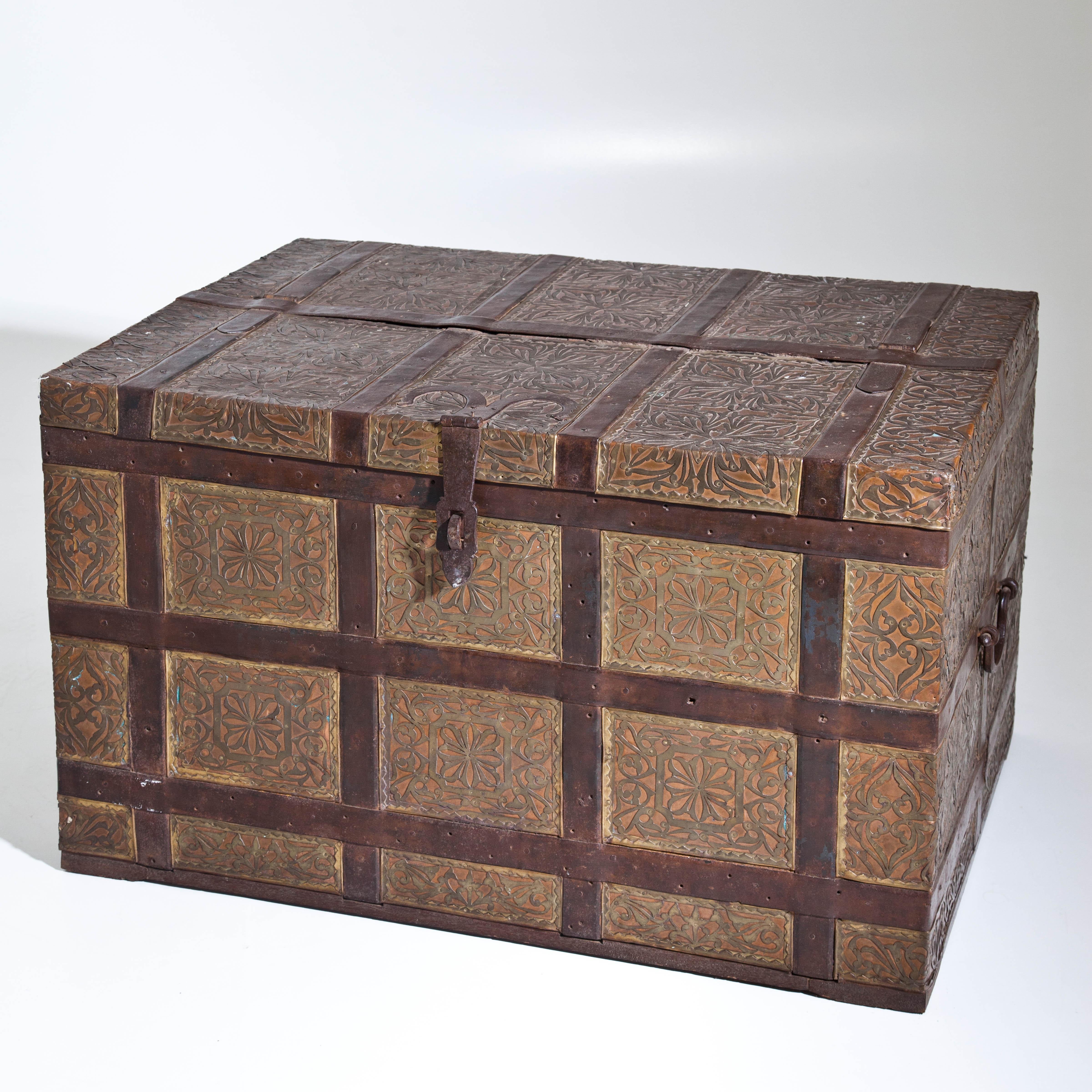 Large lidded chest with brass and copper fittings and leather cover as well as side handles.