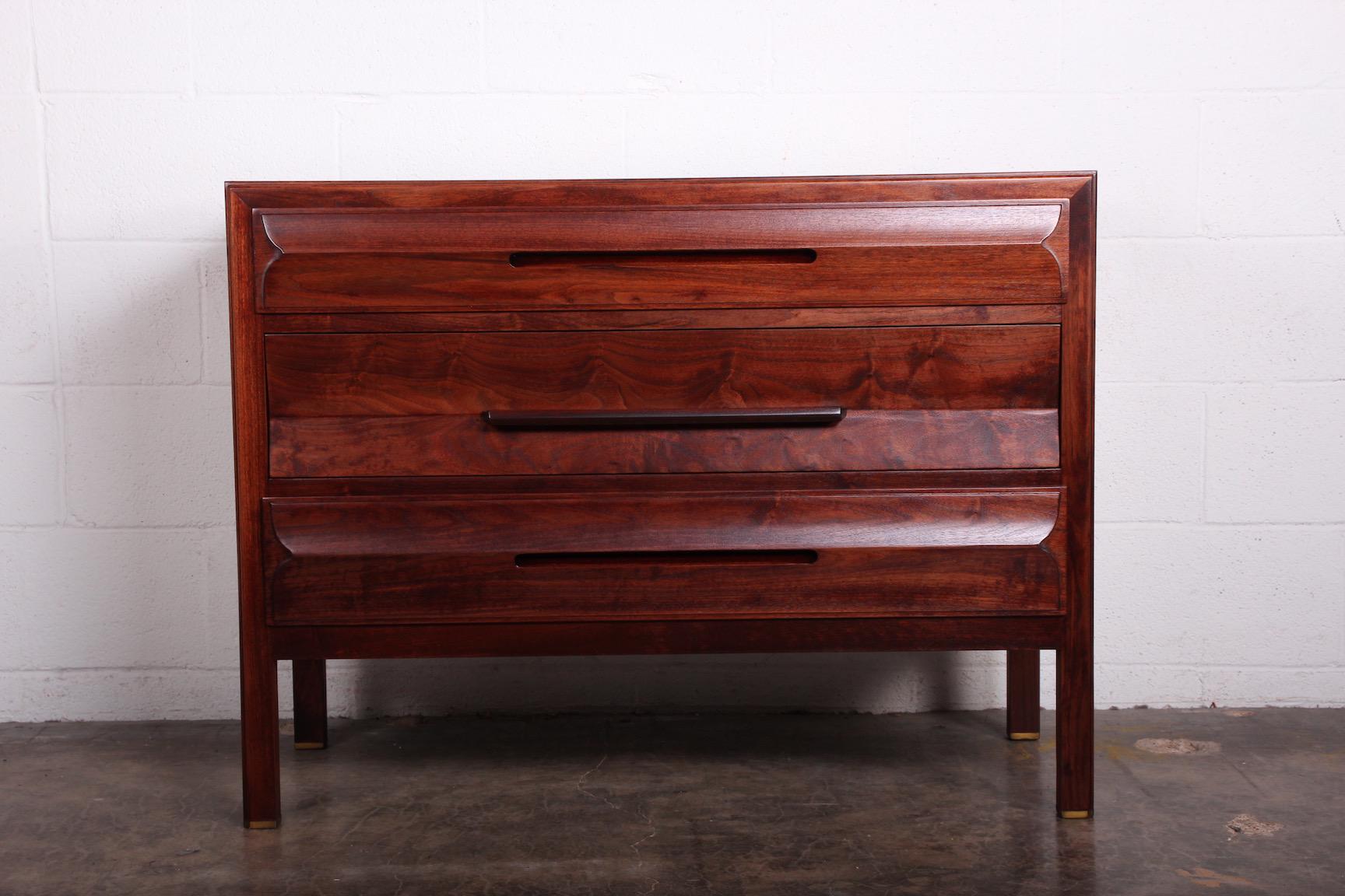 A walnut dresser with rosewood handle and brass feet. Designed by Edward Wormley for Dunbar.