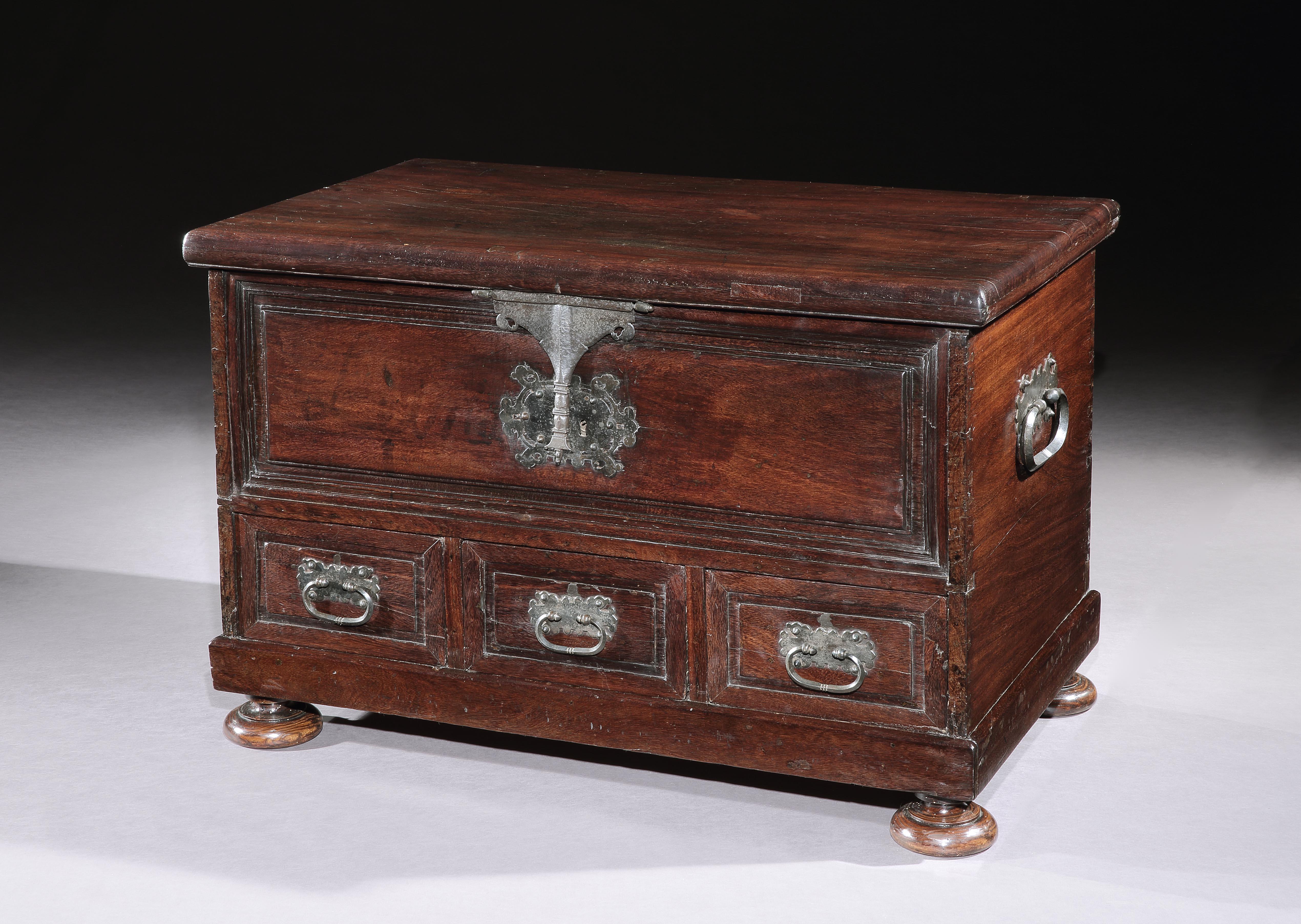 This striking chest is made from a Brazilian hardwood which I have not been able to identify. The color and figuring of the timber together with the Classic form and ornamentation supplemented by the elaborate ironwork create a simple, bold