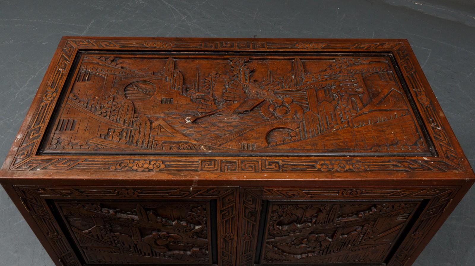 Coffre/tiroir chinois en bois de camphrier. 
Façade à deux portes derrière lesquelles se trouvent des tiroirs, richement sculptés sur tous les côtés, 
première moitié du 20e siècle.