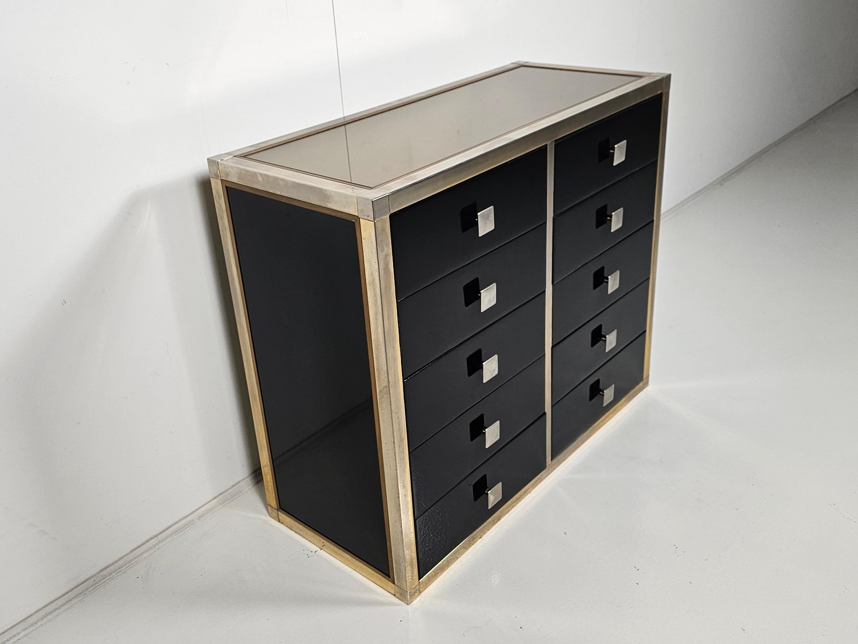 Cómoda lacada en negro diseñada por Renato Zevi en la década de 1970. Cada elemento tiene un marco de latón, paneles laminados negros, frentes y encimeras de cristal opalino. Las asas y las bisagras son de latón/cromo.

Diseños famosos como Willy