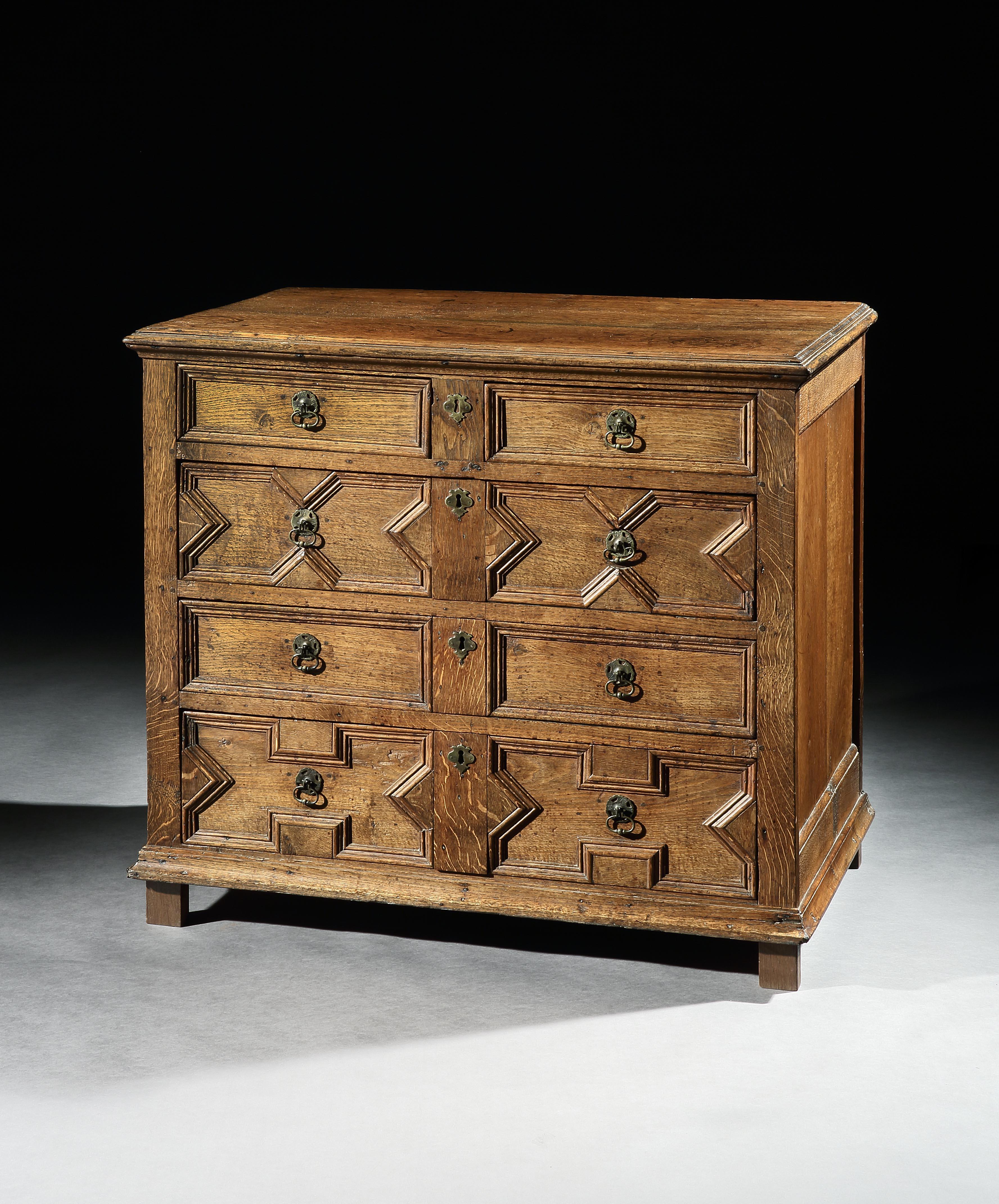 This chest of drawers has a lovely mellow color and patina. The carpenter has selected oak with fine medullary rays so that the figuring which is particularly evident on the top, down the sides and the middle of the front has become a charming