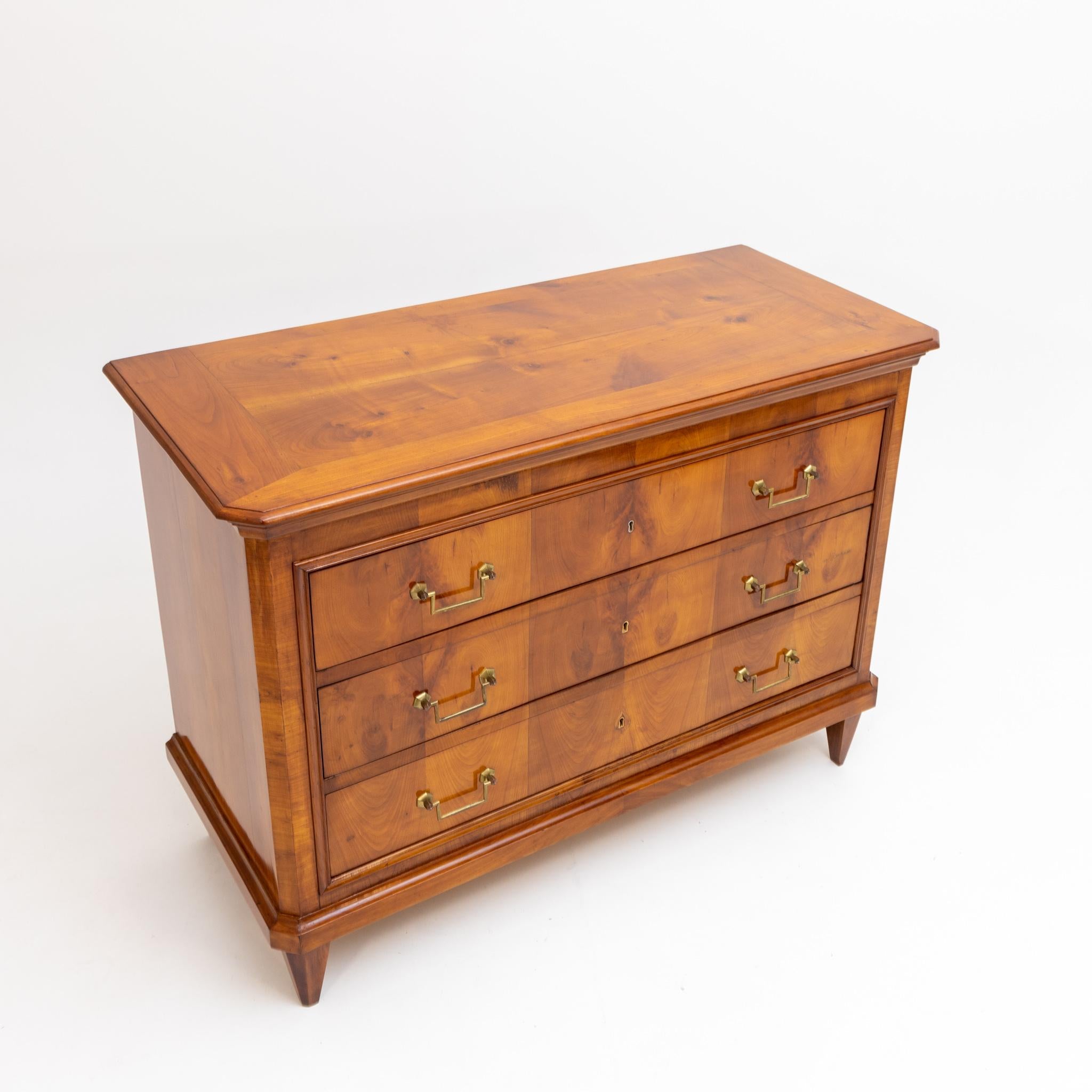 Chest of drawers in cherry veneer, with three drawers on pointed feet with profiled edges.