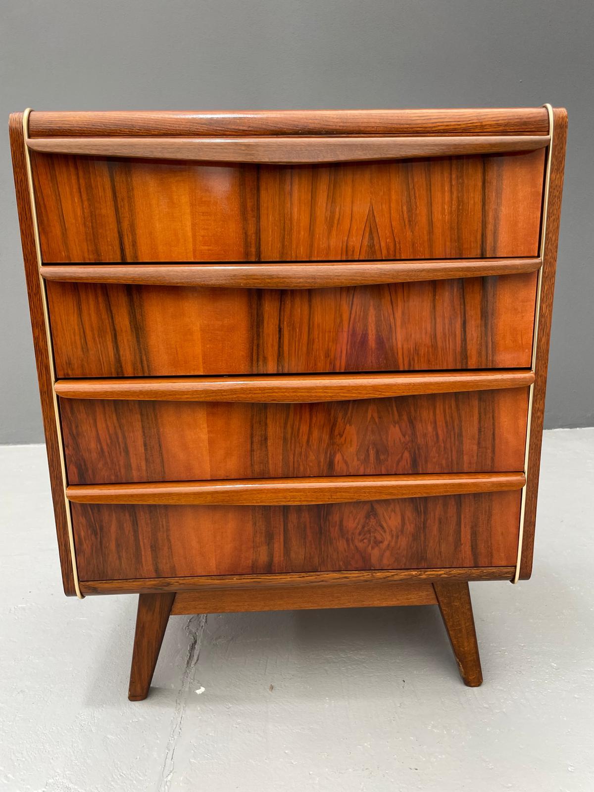 Ti proponiamo un'elegante cassettiera degli anni '60 disegnata da Bohumil Landsman, un designer associato al produttore di mobili ceco Jitona. Questo pezzo esemplifica il modernismo cecoslovacco del dopoguerra: forme pulite e compatte su gambe