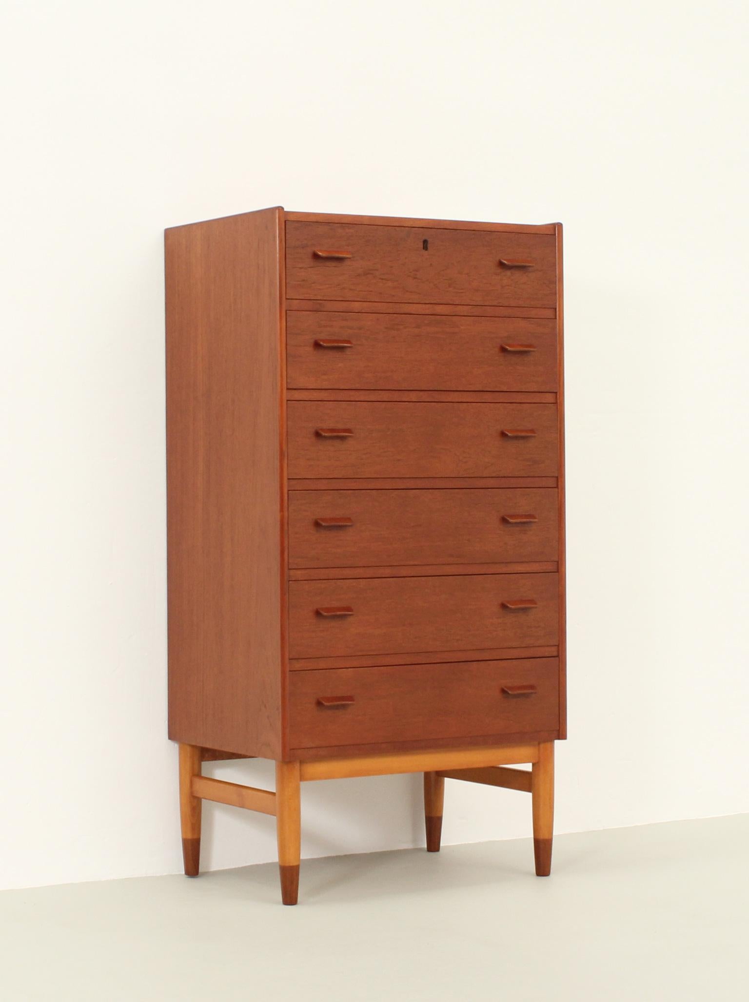 Chest of drawers designed in 1957 by Carl Aage Skov for Munch Møbler, Denmark. Slim model with six drawers in teak wood and bicolor base in oak and teak wood ends.