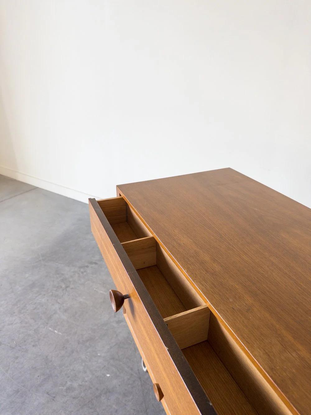 Chest of drawers by George Nelson for Herman Miller in walnut ash with wooden cupcake pulls on metal legs.
