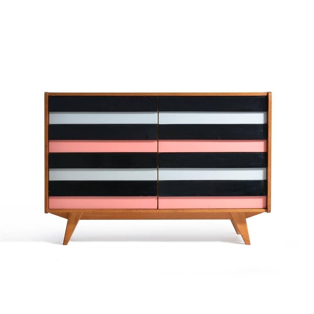 This iconic chest of drawers by Jiri Jiroutek is a design classic of Czechoslovakia. Produced by Interior Praha in 1960. The chest combines wood with formica in colorful combinations. The grey, black and pink drawers are original color. Very good,