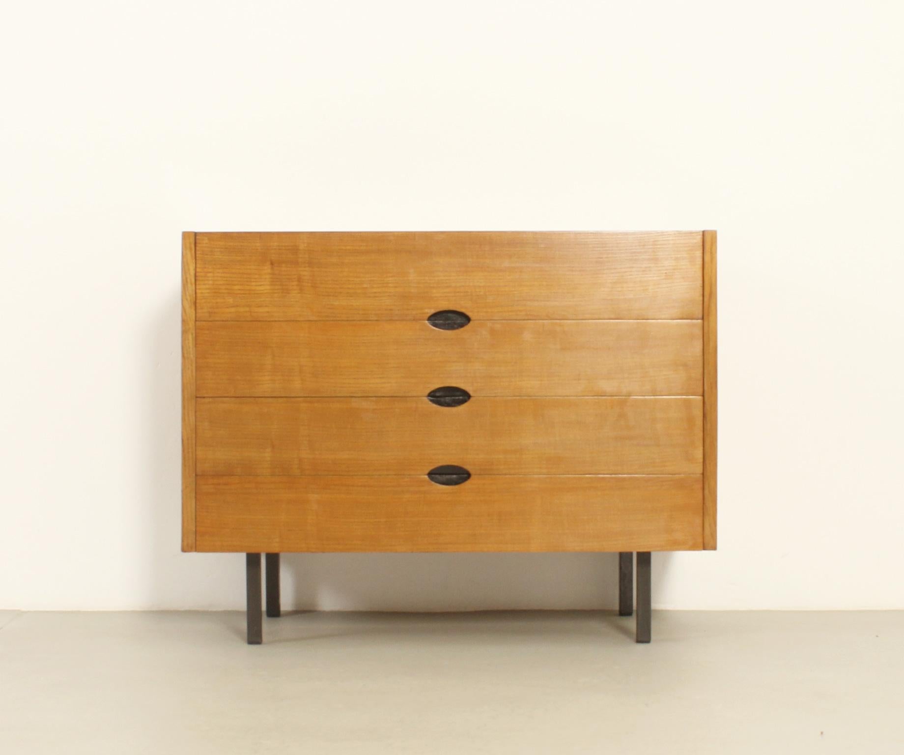 Chest of drawers designed in 1960's by Joseph-André Motte and edited by Charron, France. Oak wood with black lacquered metal legs. Three large drawers and folding top space with workspace surface.
