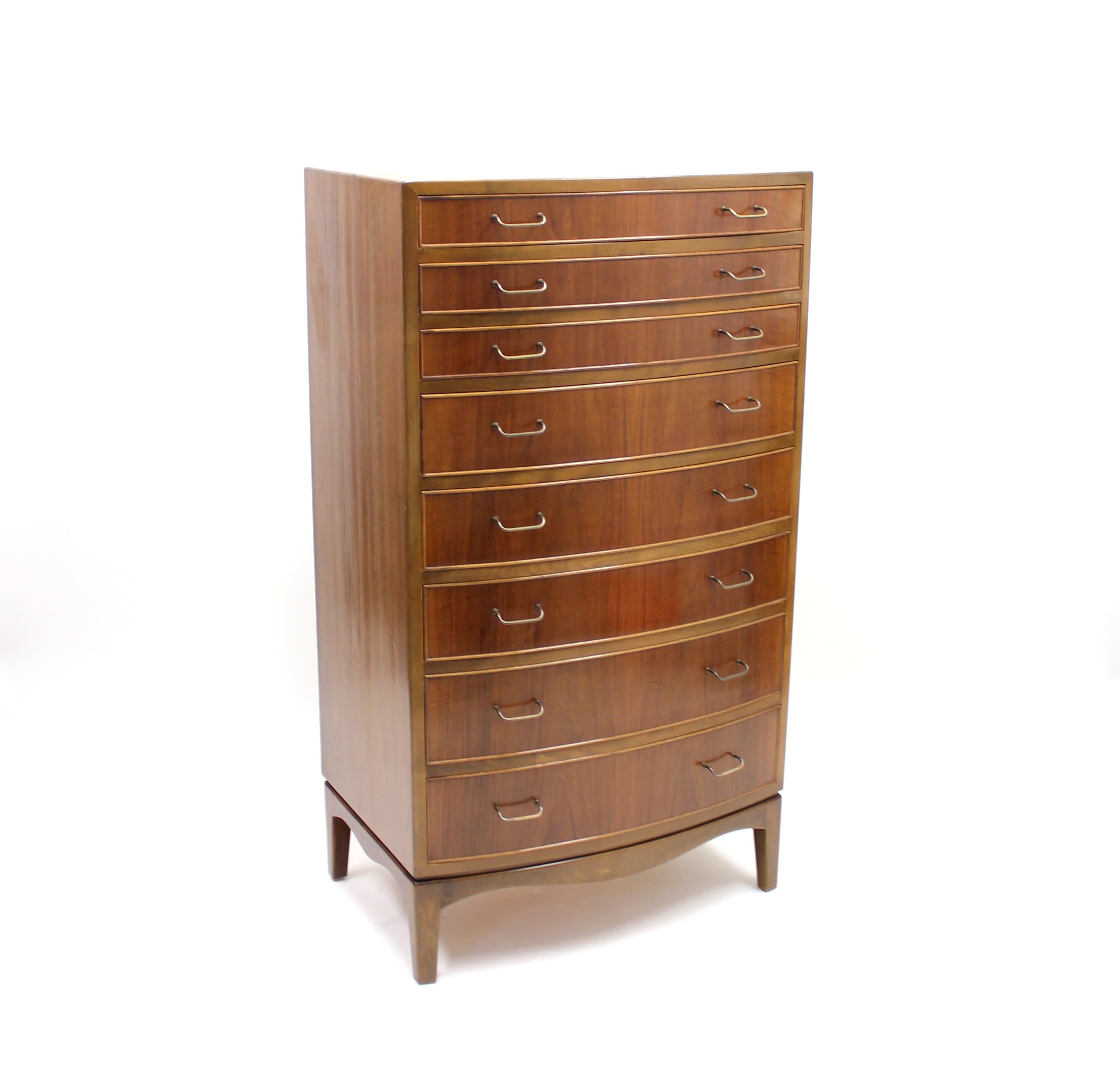 Chest of drawers or tall boy with curved front and eight drawers designed by Ole Wanscher for A.J. Iversen in the 1940s. Made of walnut and red beech with metal handles. Very good condition.