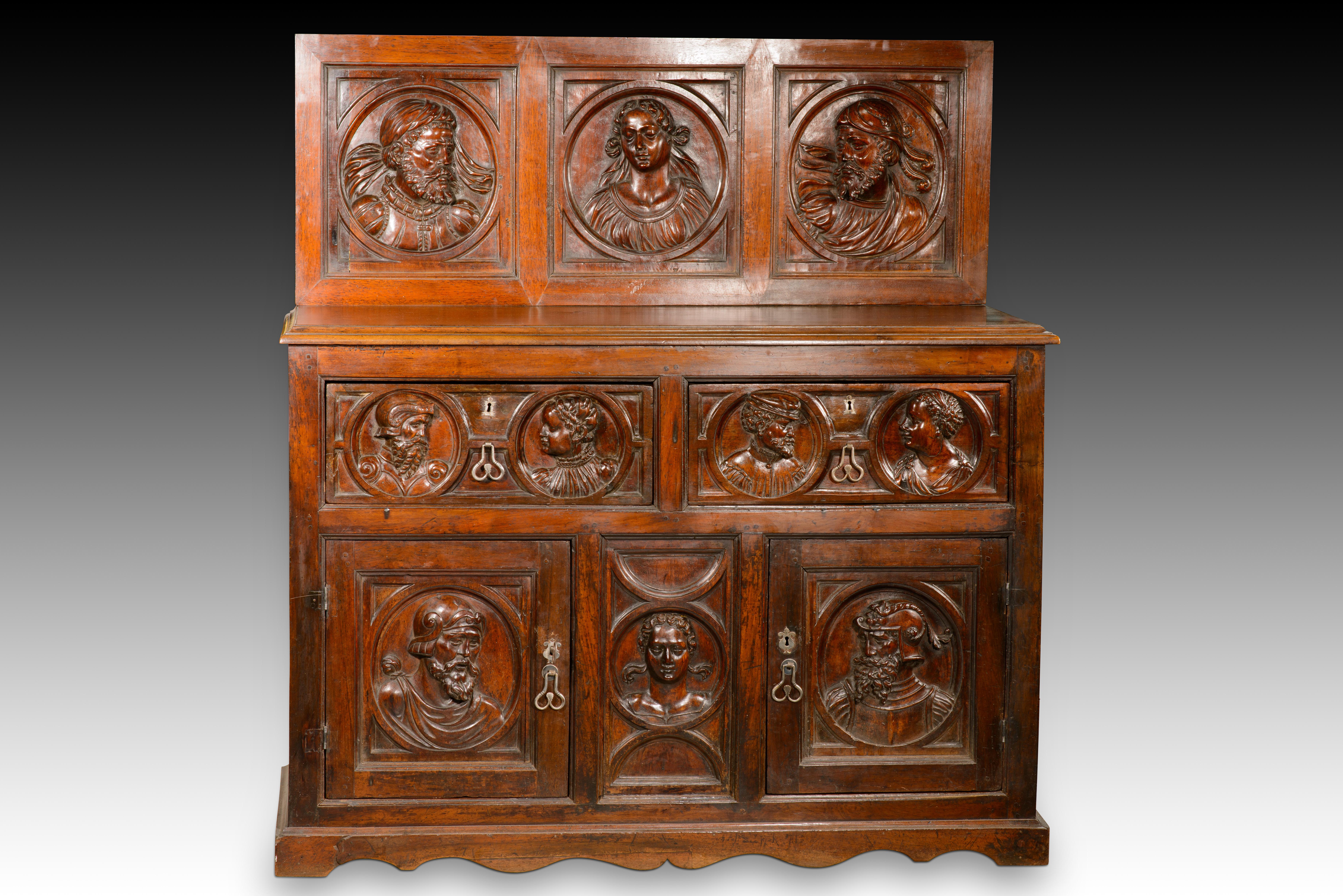  Cassettiera. Legno intagliato. XVI secolo. Restauri. 
Cassettiera con frontale in legno intagliato di colore proprio, caratterizzata da due cassetti con maniglie in metallo e serrature a scudo sopra due ante con maniglie e serrature simili alle