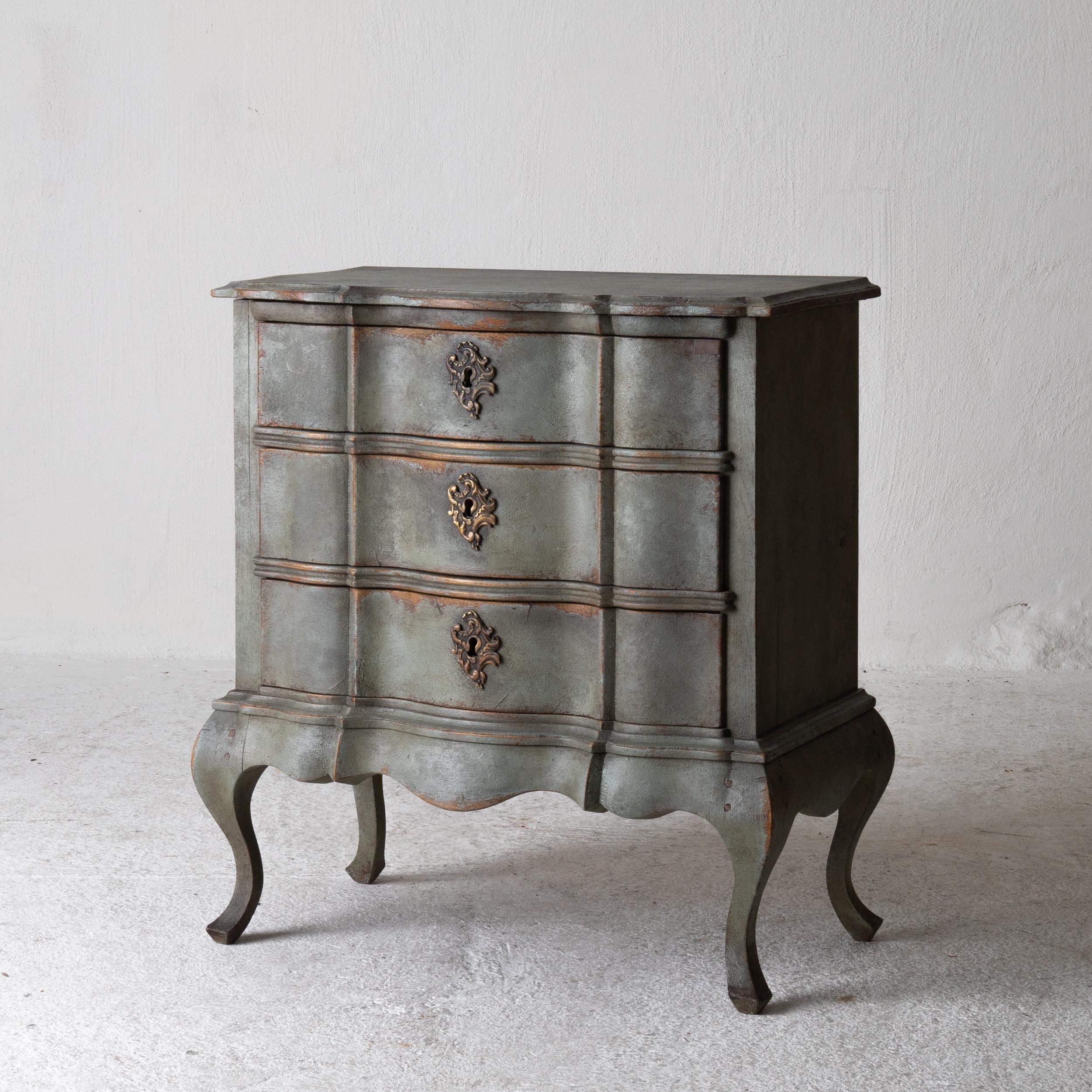Chest of drawers Swedish Rococo 1750-1775 Greenish Blue, Sweden.
A smaller chest of drawers perfect as a nightstand or side table made during the Rococo period in Denmark. Painted in a greenish blue with stunning patina. Original brass hardware.