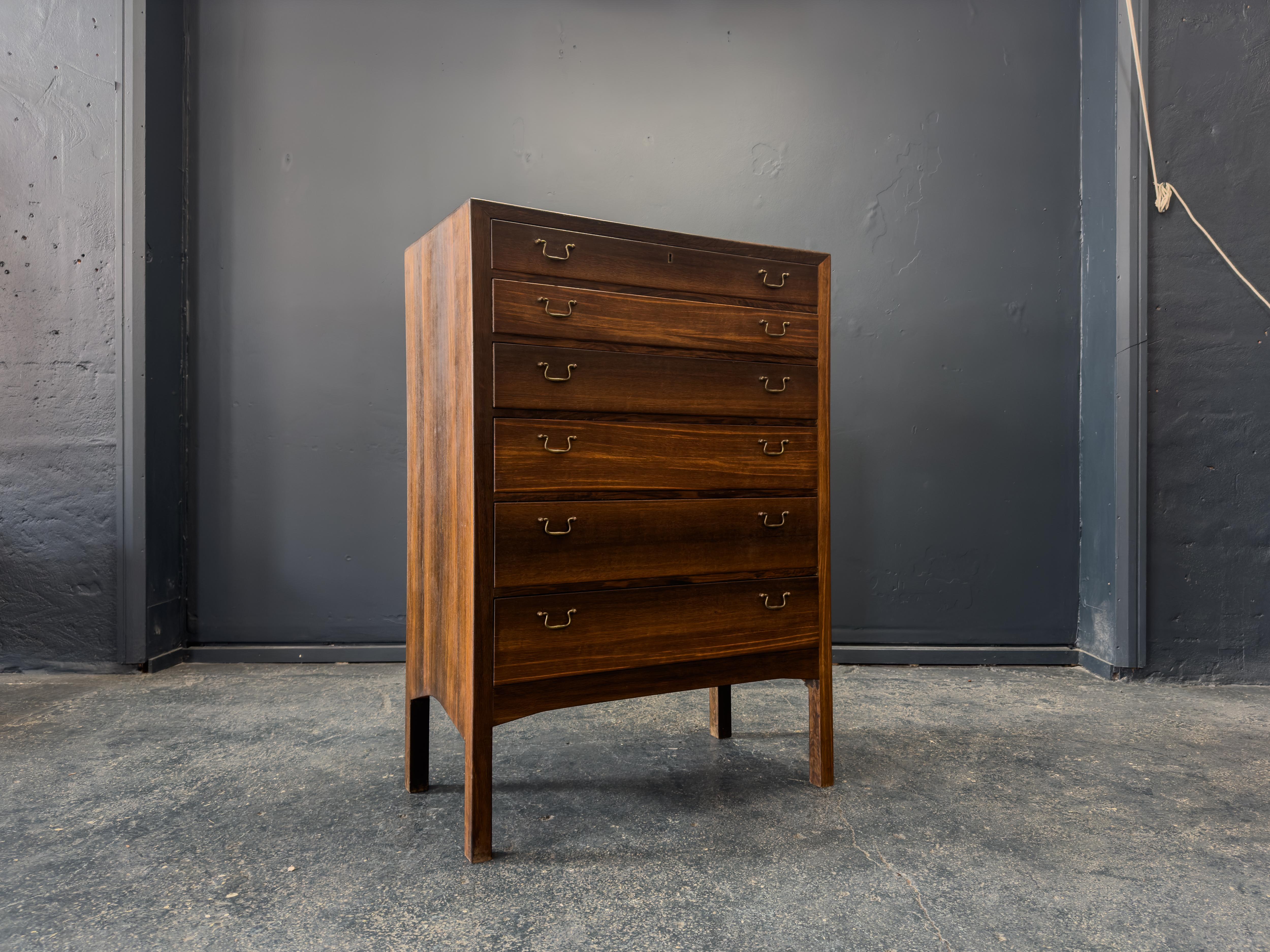 Questa squisita cassettiera è uno splendido esempio di design danese di metà secolo, caratterizzato da una forma elegante e da una lavorazione artigianale di qualità superiore. Realizzata in legno con una ricca venatura, la cassapanca presenta toni
