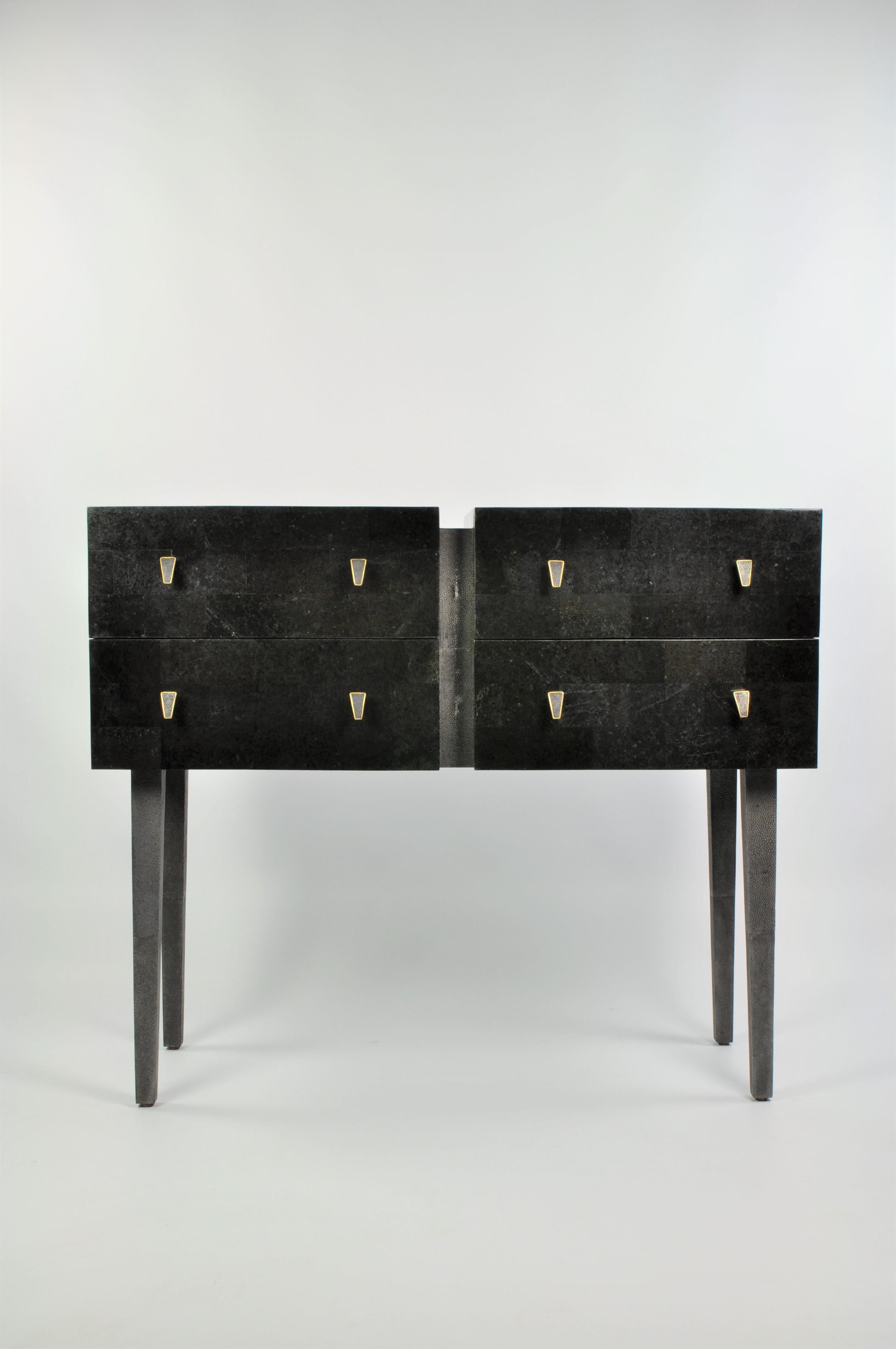 This chest of drawers is made of black stone marquetry with shagreen details on the top and the legs. It has four drawers.
The handles are made in lost wax cast brass with an antic brass patina and shagreen.
The interior of the drawers is in wenge