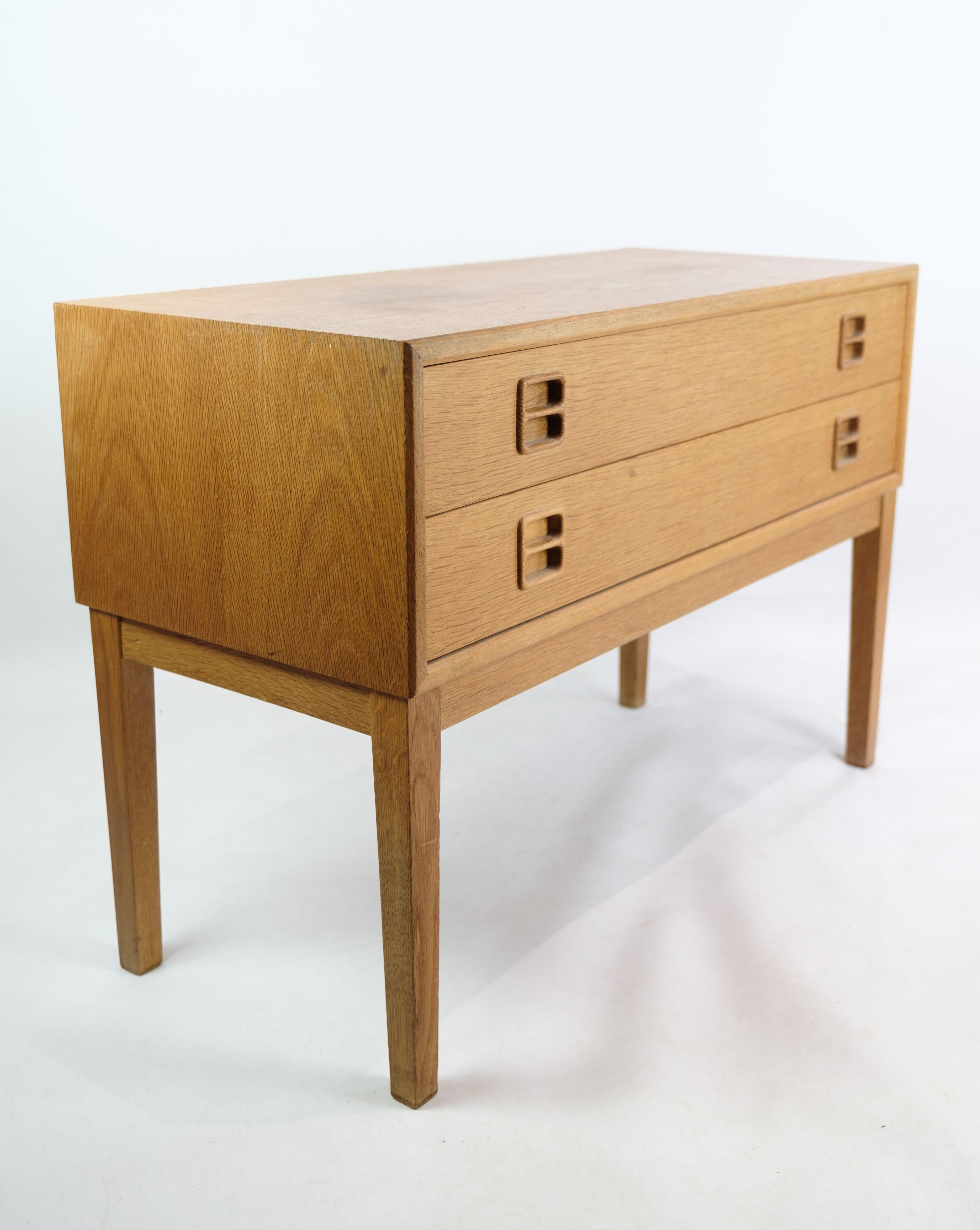 Oblong chest of drawers in oak with 2 drawers and wooden handles of Danish furniture design from around the 1960s. The furniture appears in very fine used condition and is well suited to be both entrance furniture, as well as storage