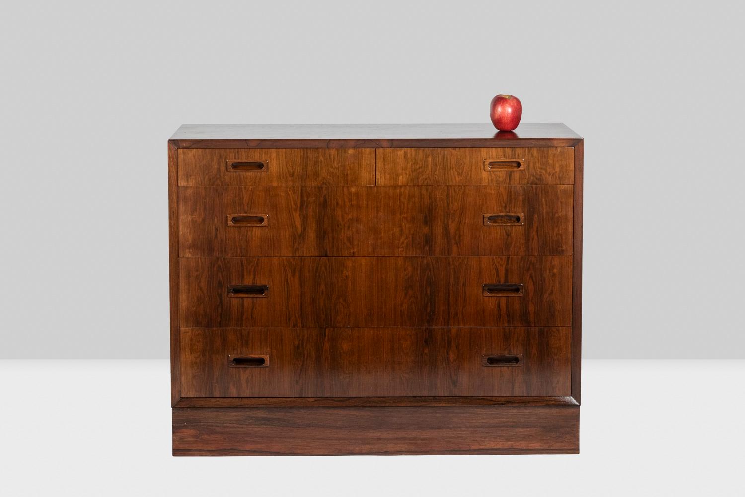 Chest of drawers in rosewood opening with four drawers on the front, the drawer frame with a beveled finish. Handles in a rectangular shape.

Danish work realized in the 1970s.
