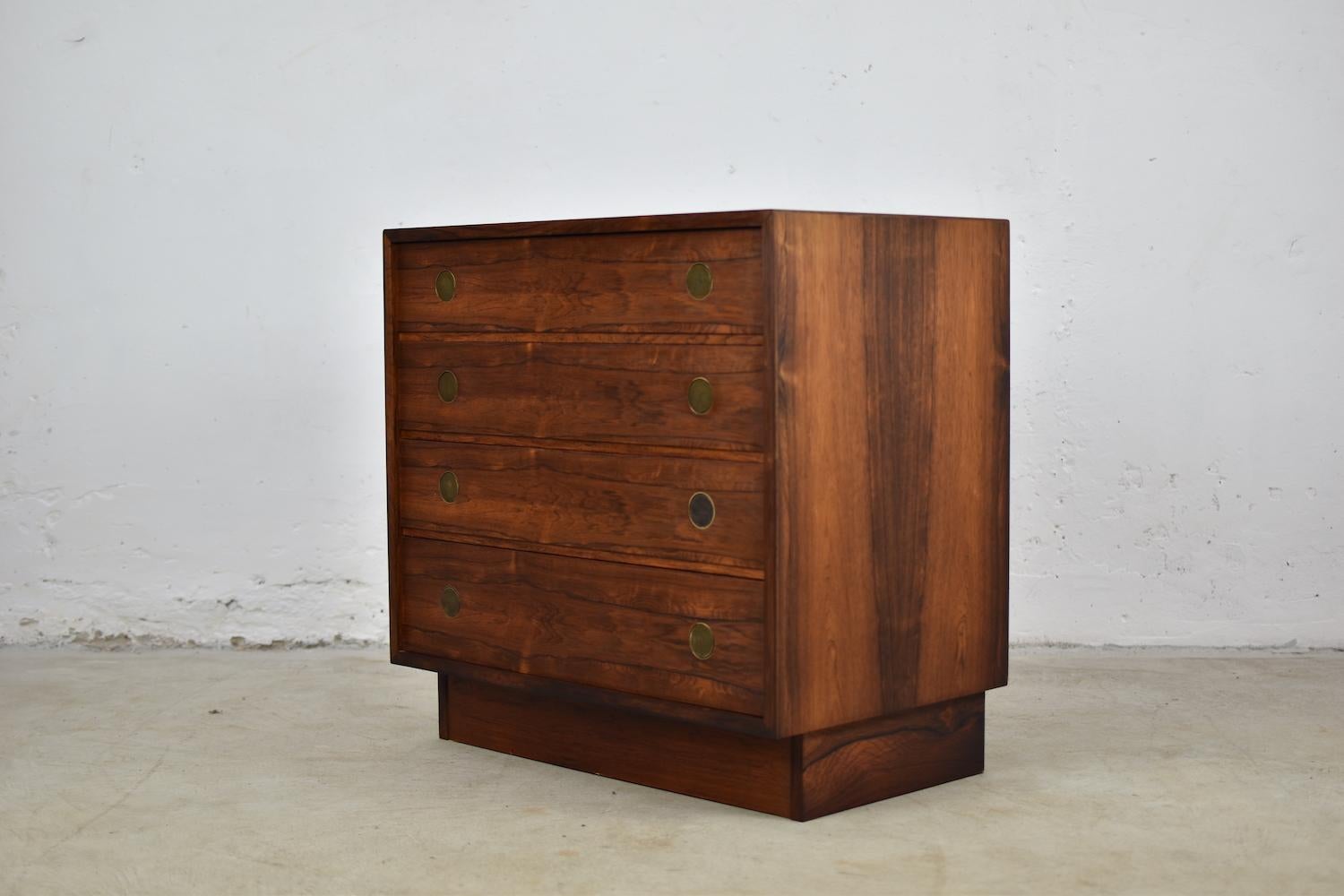 Lovely chest of drawers produced by Dyrlund, Denmark, 1960s. This rosewood cabinet has four marvelous drawers all with bronze circular handles. Impressive patina. Masterpiece.