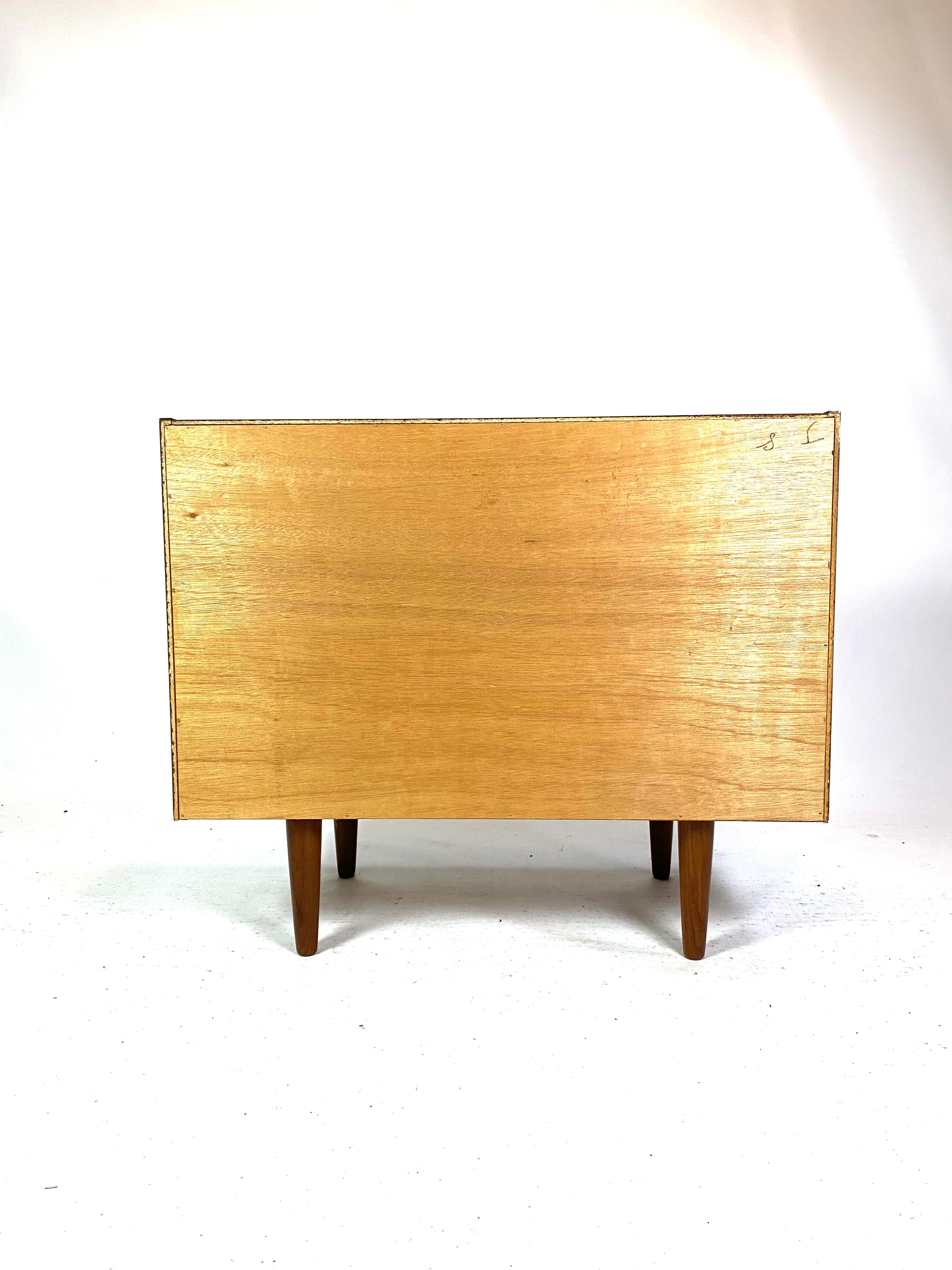 Holen Sie sich ein Stück Möbelgeschichte mit dieser eleganten Palisander-Kommode aus den 1960er Jahren. Das Palisanderholz verleiht der Kommode einen warmen und natürlichen Glanz und unterstreicht gleichzeitig die feine Handwerkskunst, die für das