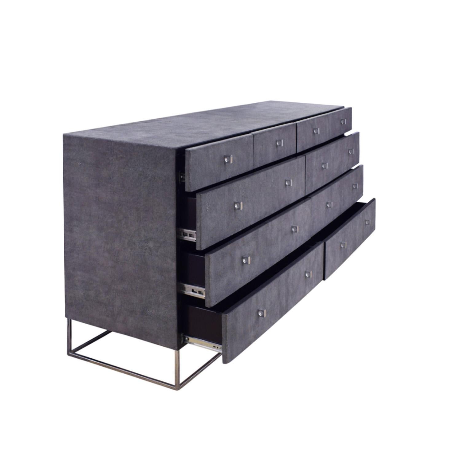 Chest of drawers in gray shagreen embossed leather with polished chrome base and pulls, custom design, American 1970’s. We have installed self-close glides. Interior of drawers lacquered black. A very chic design.  We have replaced the glides on the