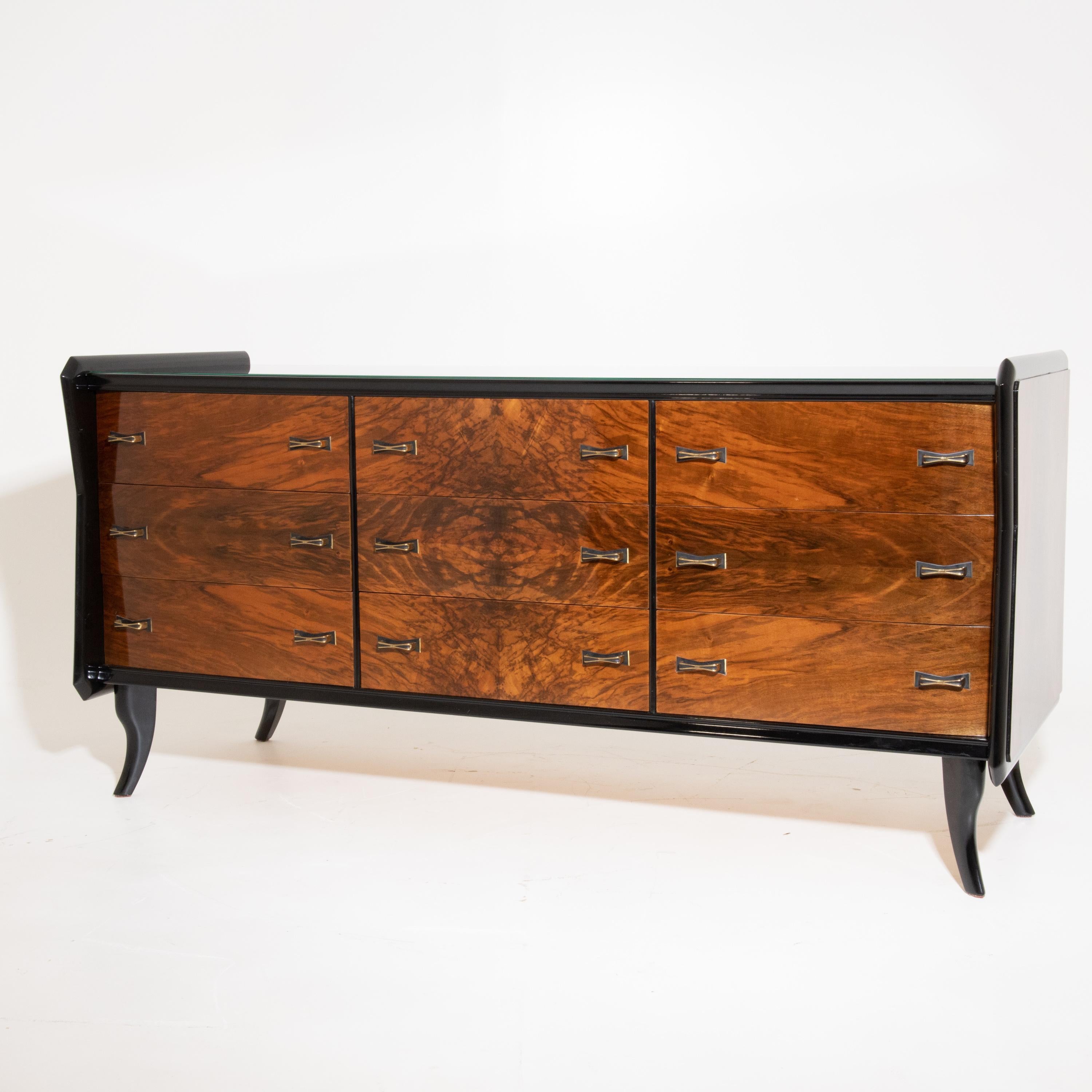 Partly ebonized sideboard with nine drawers standing on flared feet. The handles are x-shaped and made of brass. The front shows a very nice walnut veneer pattern. The two-door bedside cabinets (56 x 50 x 35.5 cm) are also available and have a