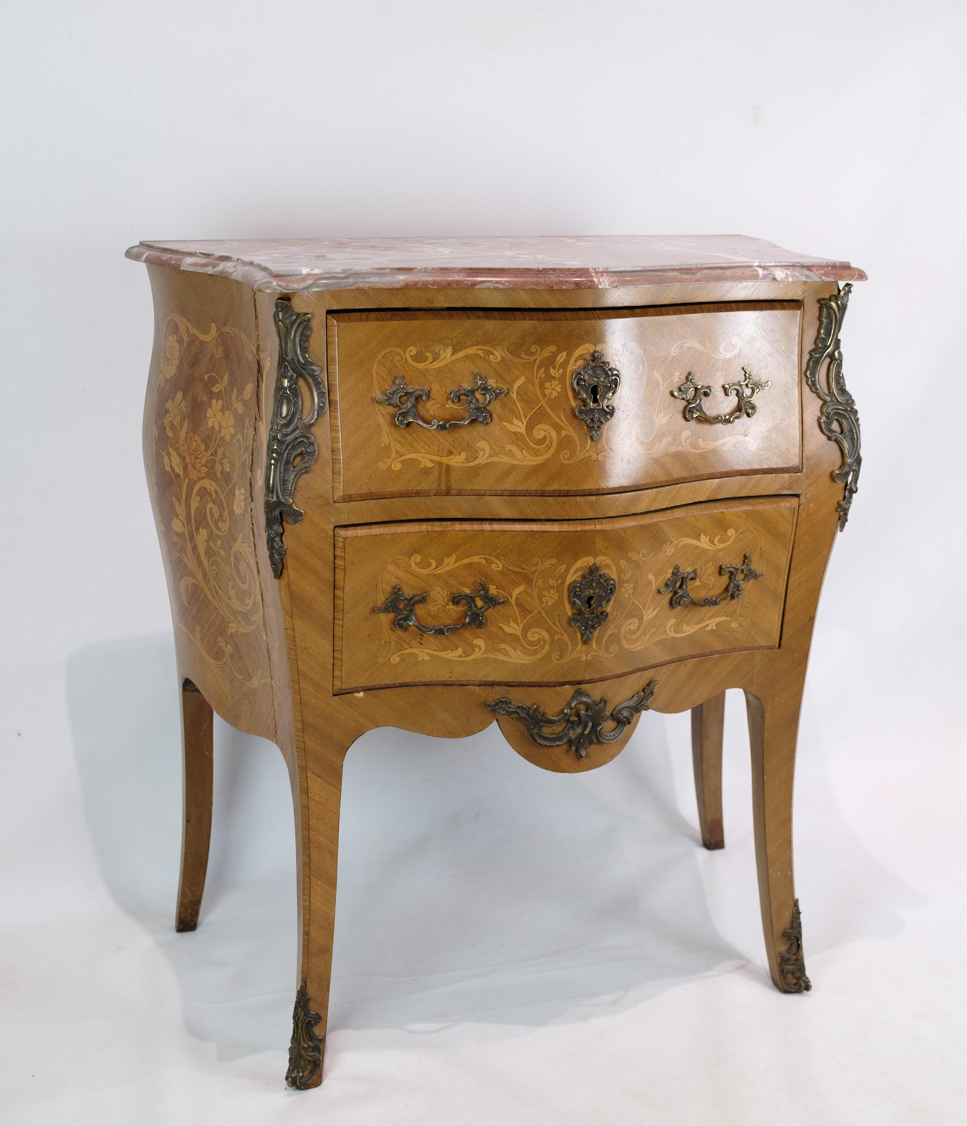 The Rococo chest of drawers you describe from the 1860s exudes the opulence and elegance characteristic of the Rococo style. Crafted from walnut wood, known for its warmth and depth, and crowned with a marble top, this chest of drawers makes an
