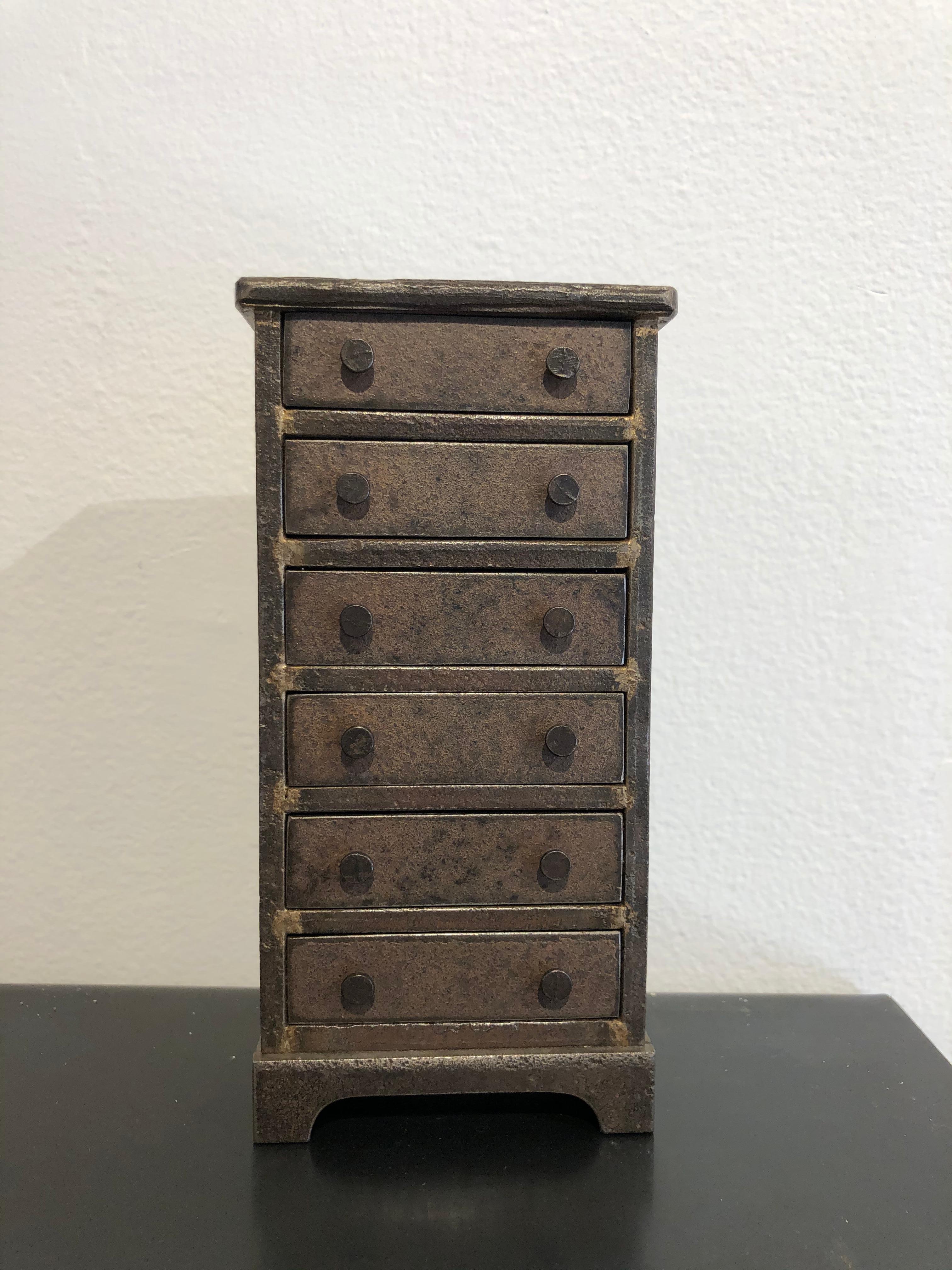 This exquisite miniature chest of drawers is inspired by Shaker furniture. Made from welded steel with a natural rust patina and vintage nail-heads for the pulls, this chest has fully functioning drawers. Despite it's small size, it makes quite an
