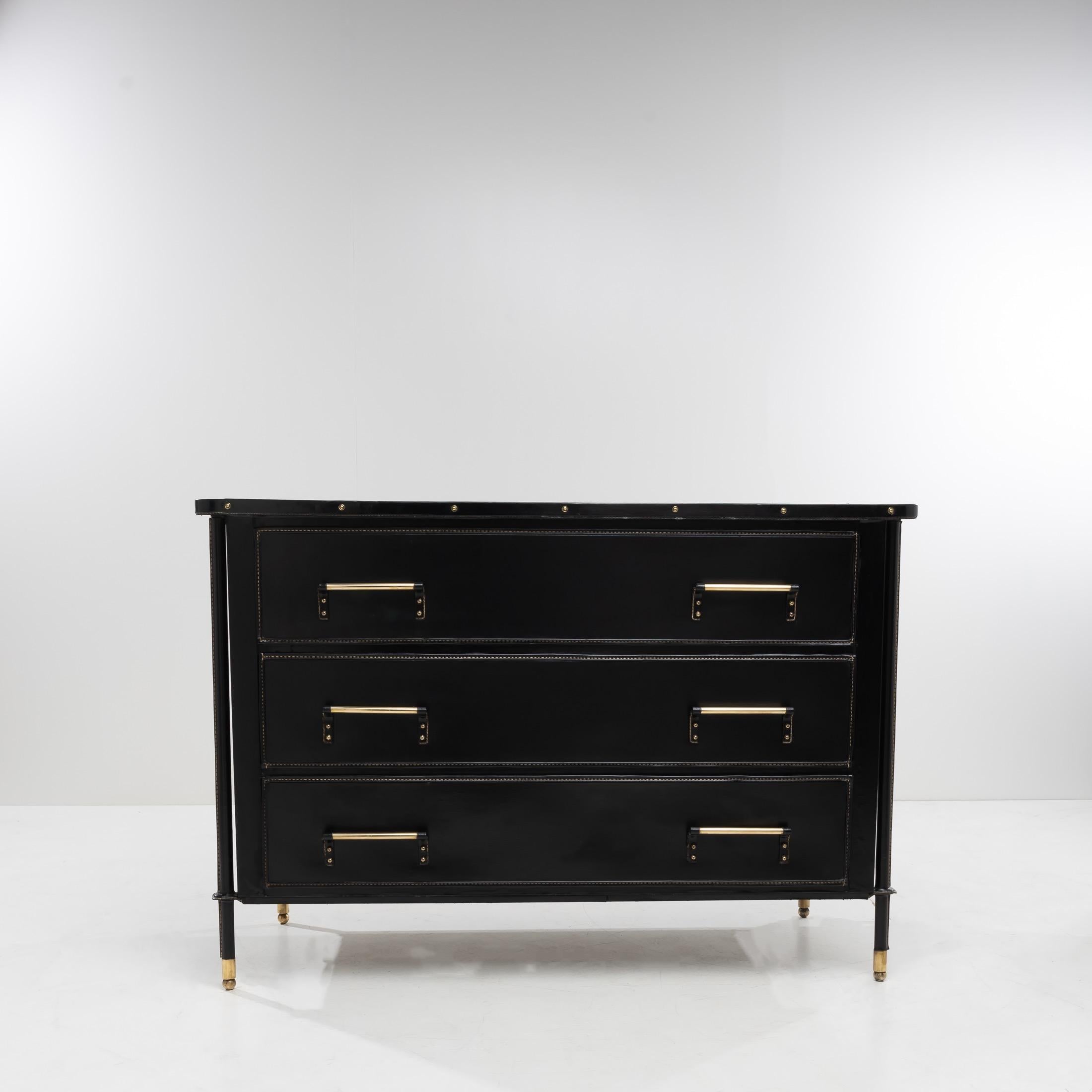 Chest of large drawers whose wooden structure is entirely sheathed in saddle stitched black imitation leather.
The front legs run along the sides of the cabinet to join the underside of the upper plate, they are also sheathed.
Each foot is