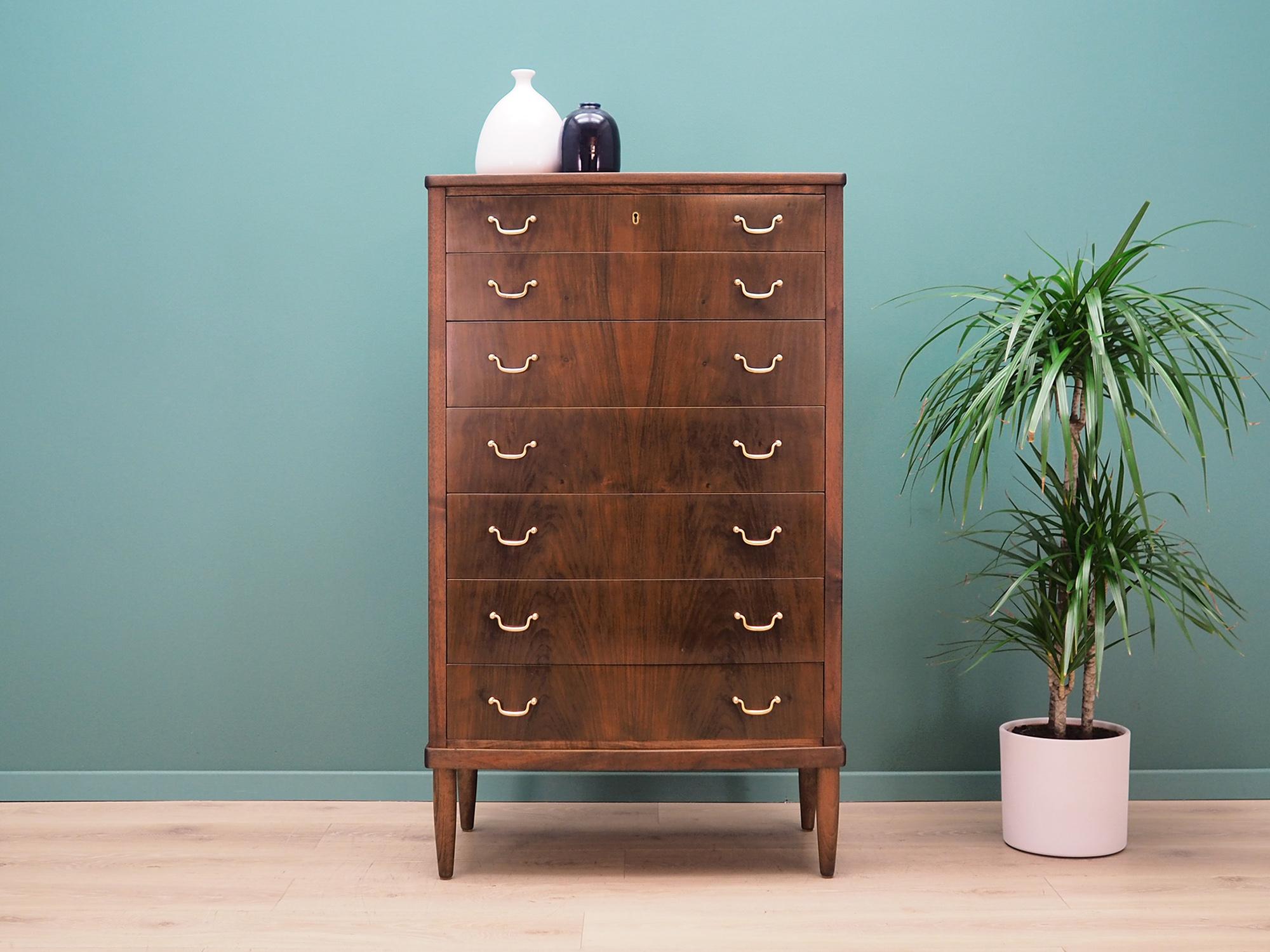 The chest of drawers was made in the 1960s, Danish production.

The construction is covered with walnut veneer. The legs are made of solid walnut wood, the handles are made of metal. The surface after refreshing. The cabinet is a classic chest of