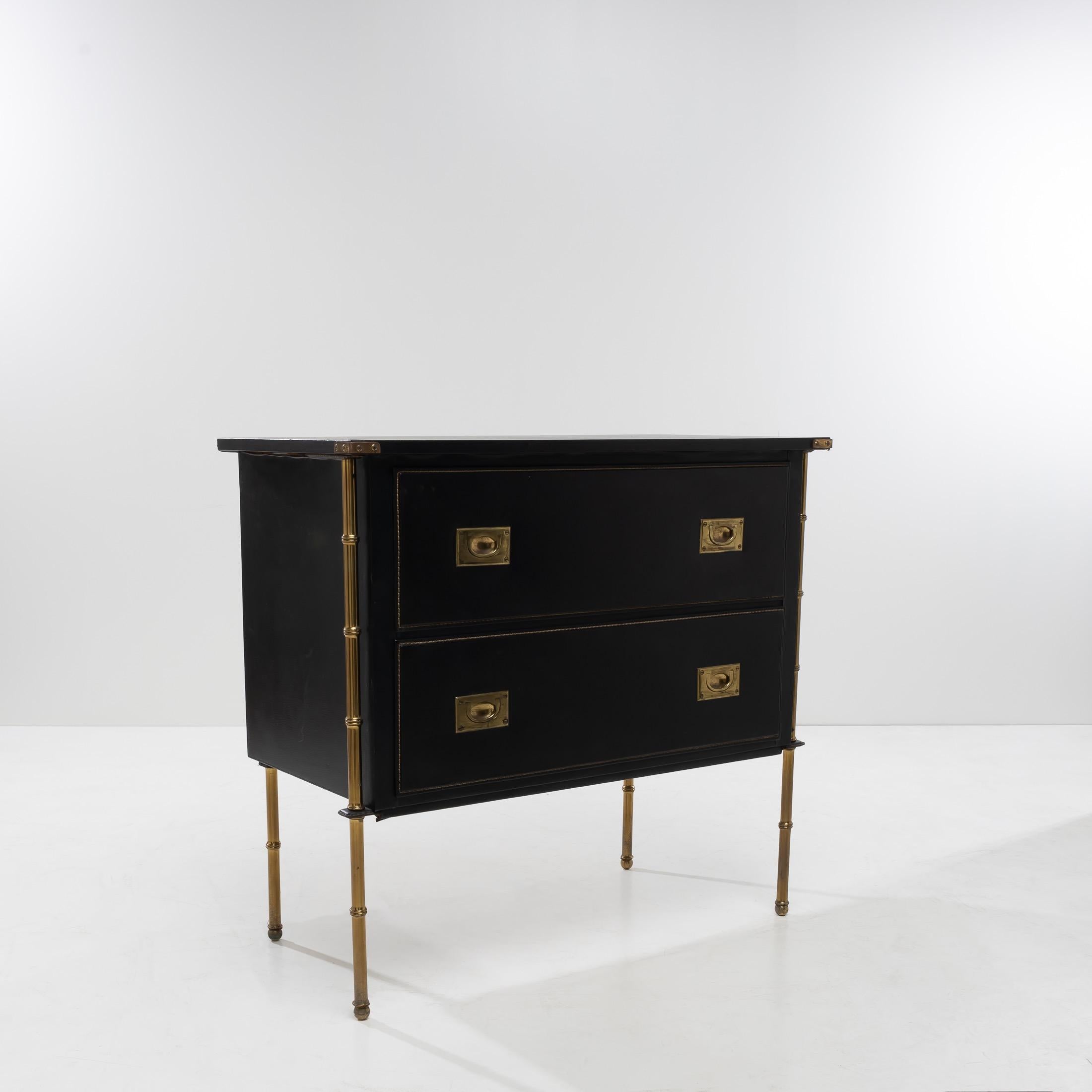 About this Chest of drawers with two drawers by Jacques Adnet
Chest of drawers with two drawers, the wooden structure entirely covered in black imitation leather.
The brass feet in faux-bamboo finished with balls. On the front, they extend along