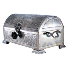 Chest-shaped silver jewelry box with plant engravings and key