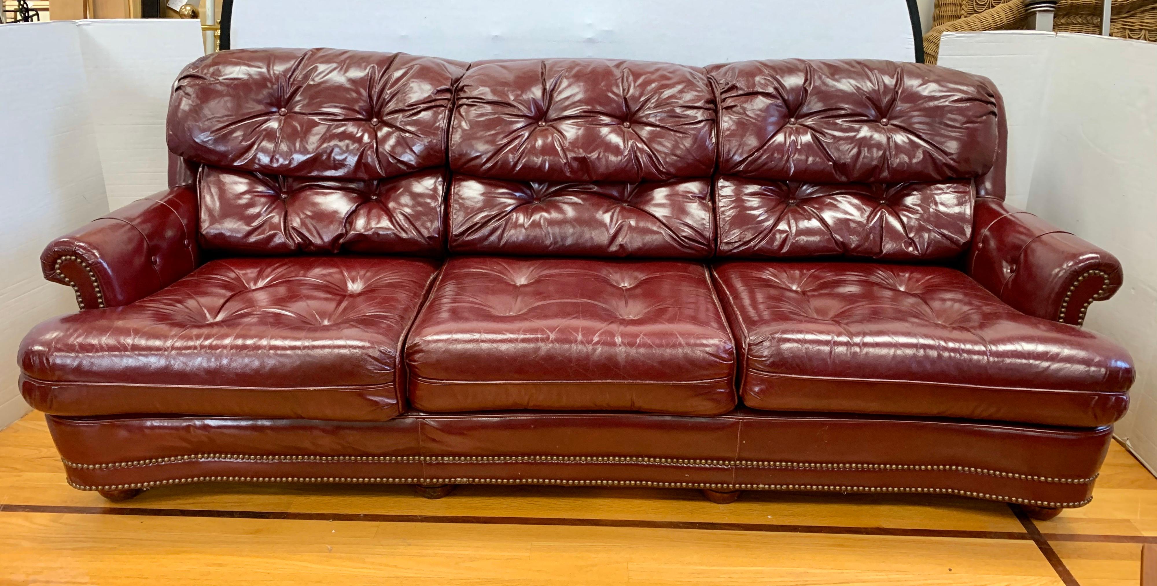 Classic leather 100% burgundy leather chesterfield sofa that measures seven feet wide.
Elegant brass nailheads run around the whole piece. One of the most comfortable sofas
you have ever sat in. The leather is broken in perfectly.