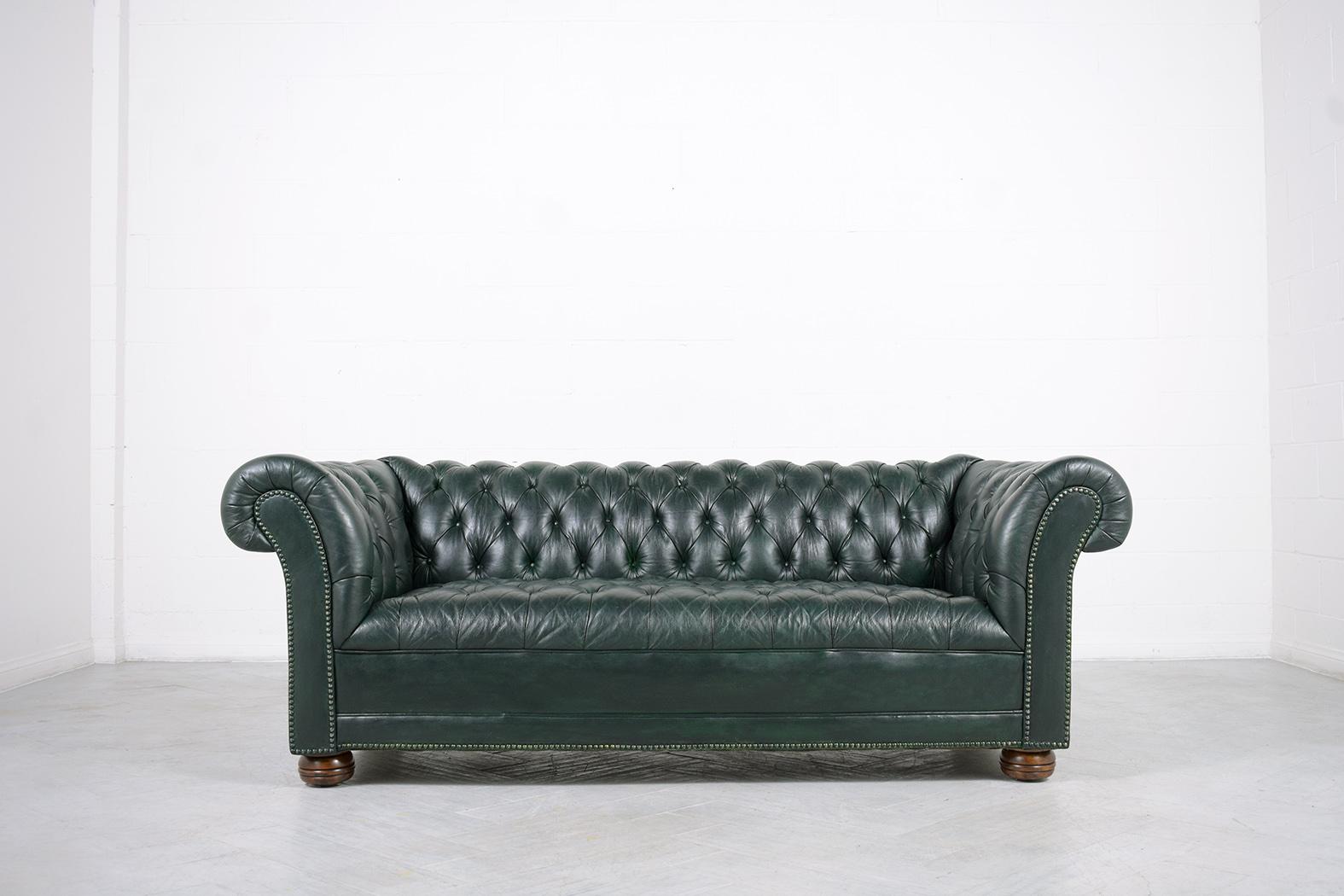 An extraordinary vintage green leather tufted chesterfield sofa in great condition is crafted out of solid wood and leather combination completely restored by our professional craftsmen team and has been newly dyed in a custom dark green color. The